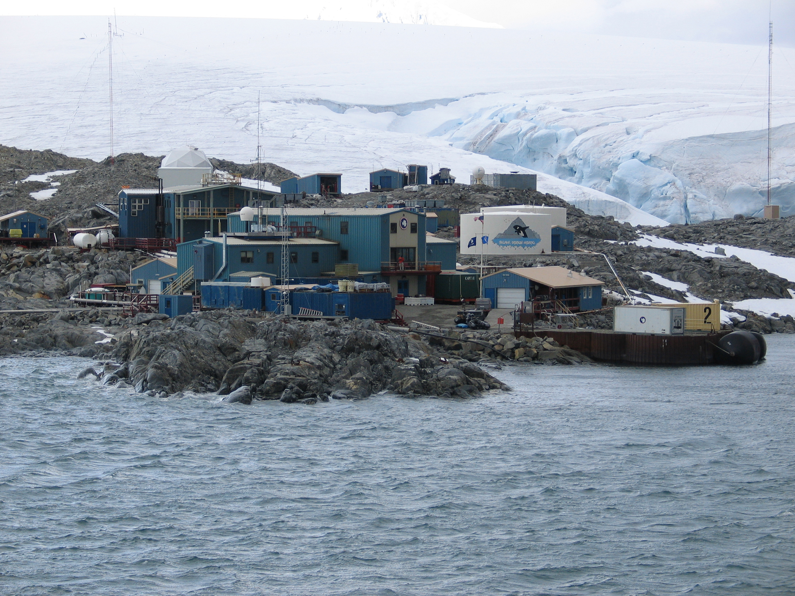 Blue buildings on a rocky cape.