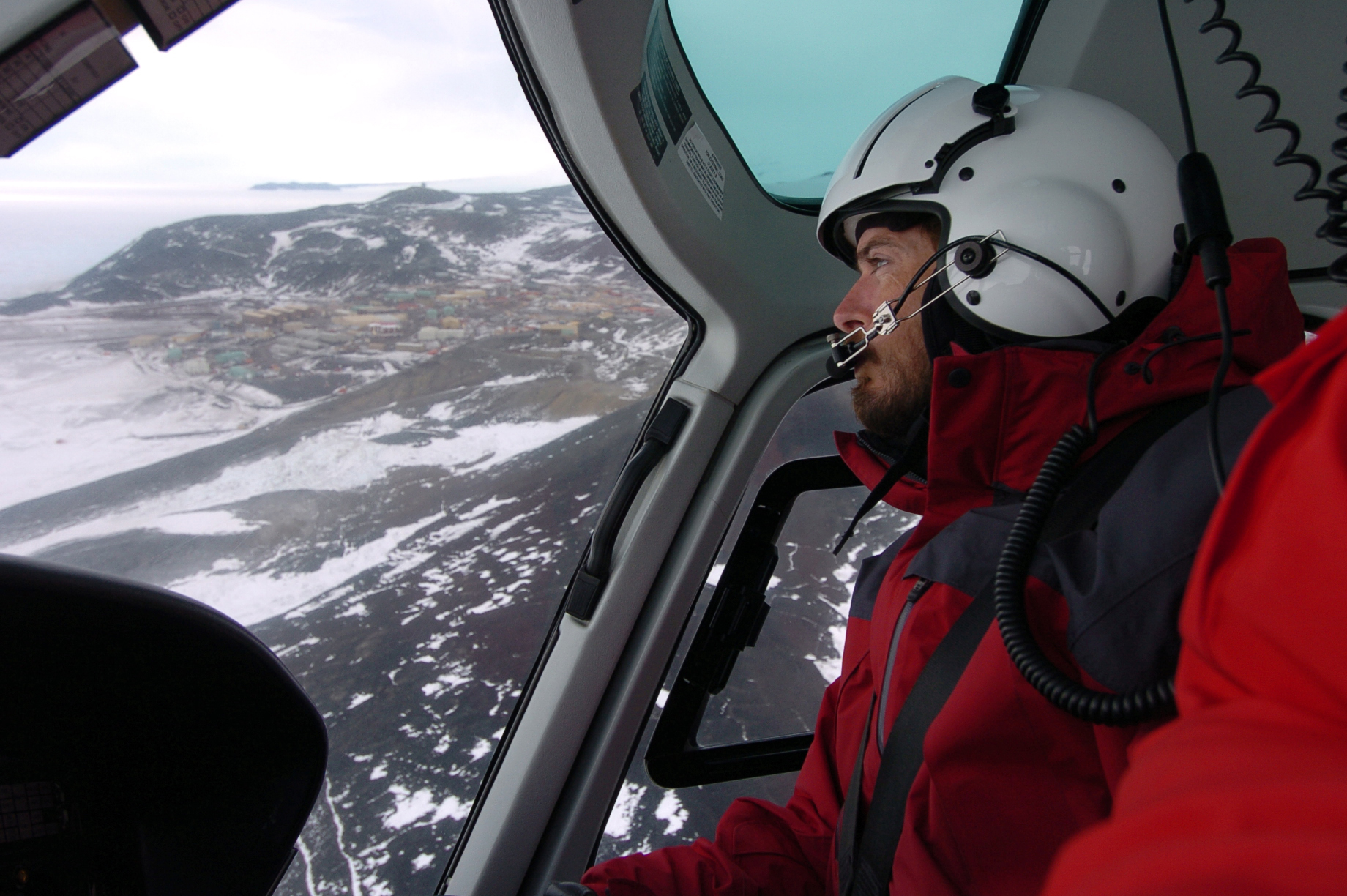 A helicopter pilot and view of terrain below.