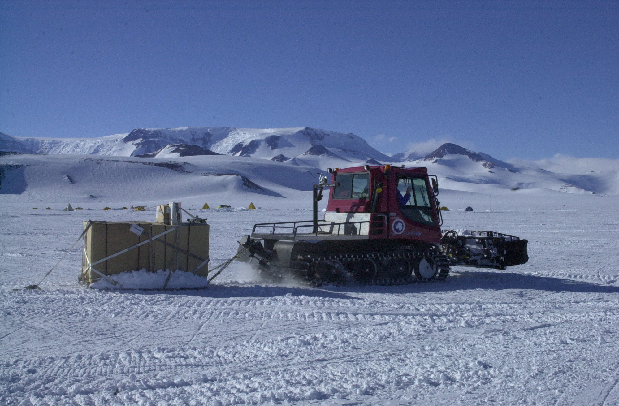 A tracked vehicle moves over the snow.