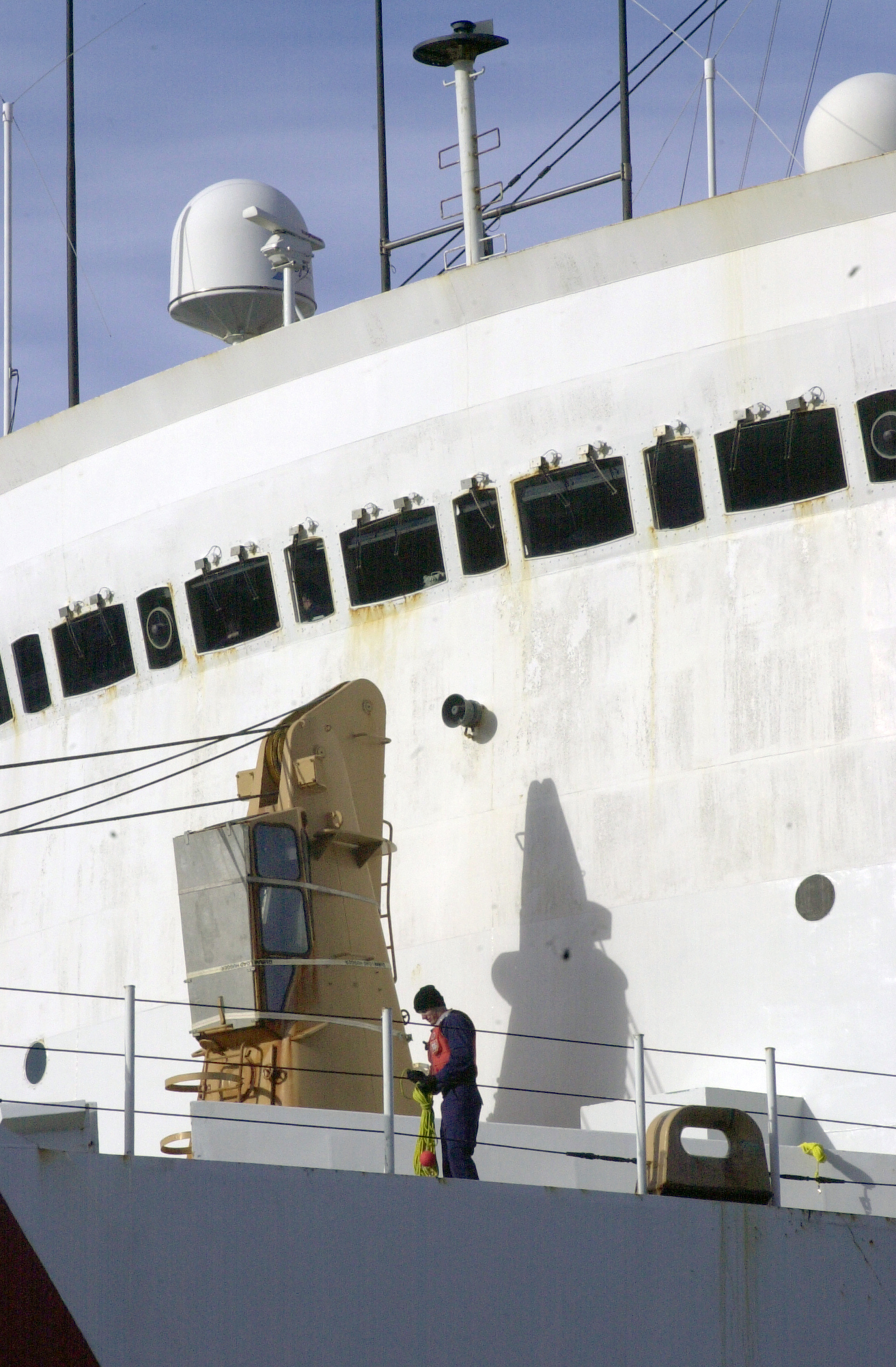 A person works in front of a large white structure.