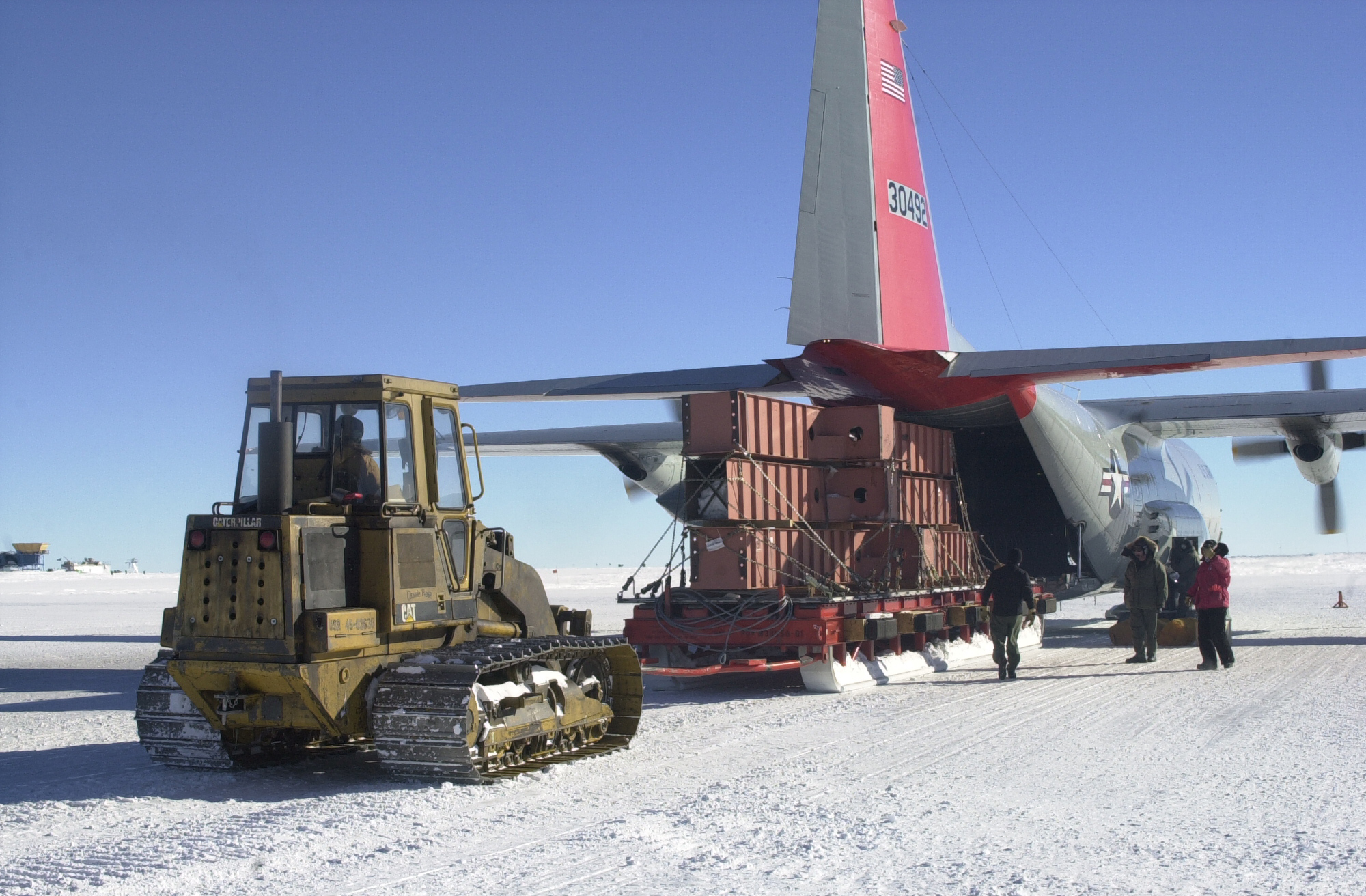 A tractor unloading cargo from the rear of an airplane.