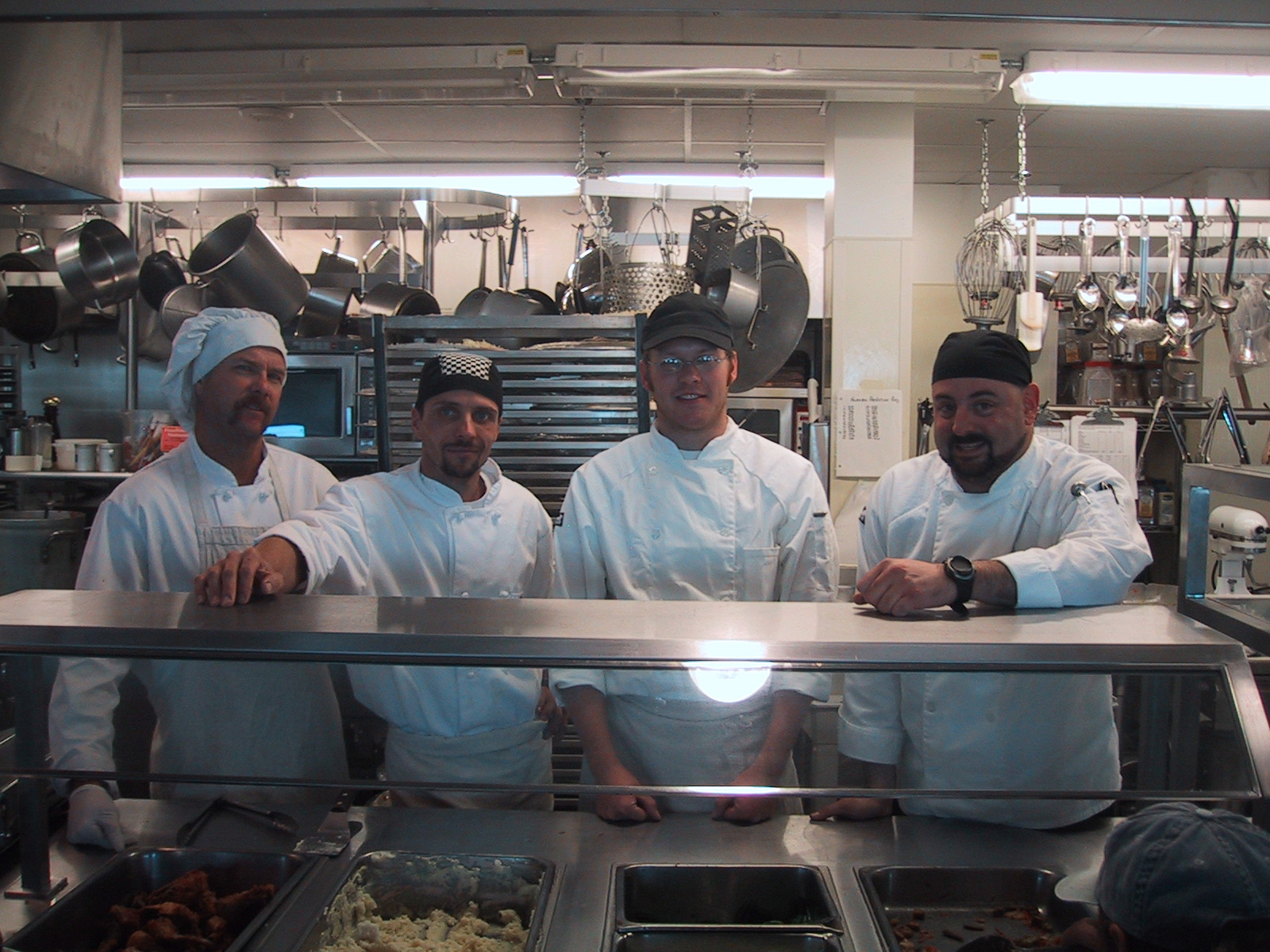 Four men in a kitchen.