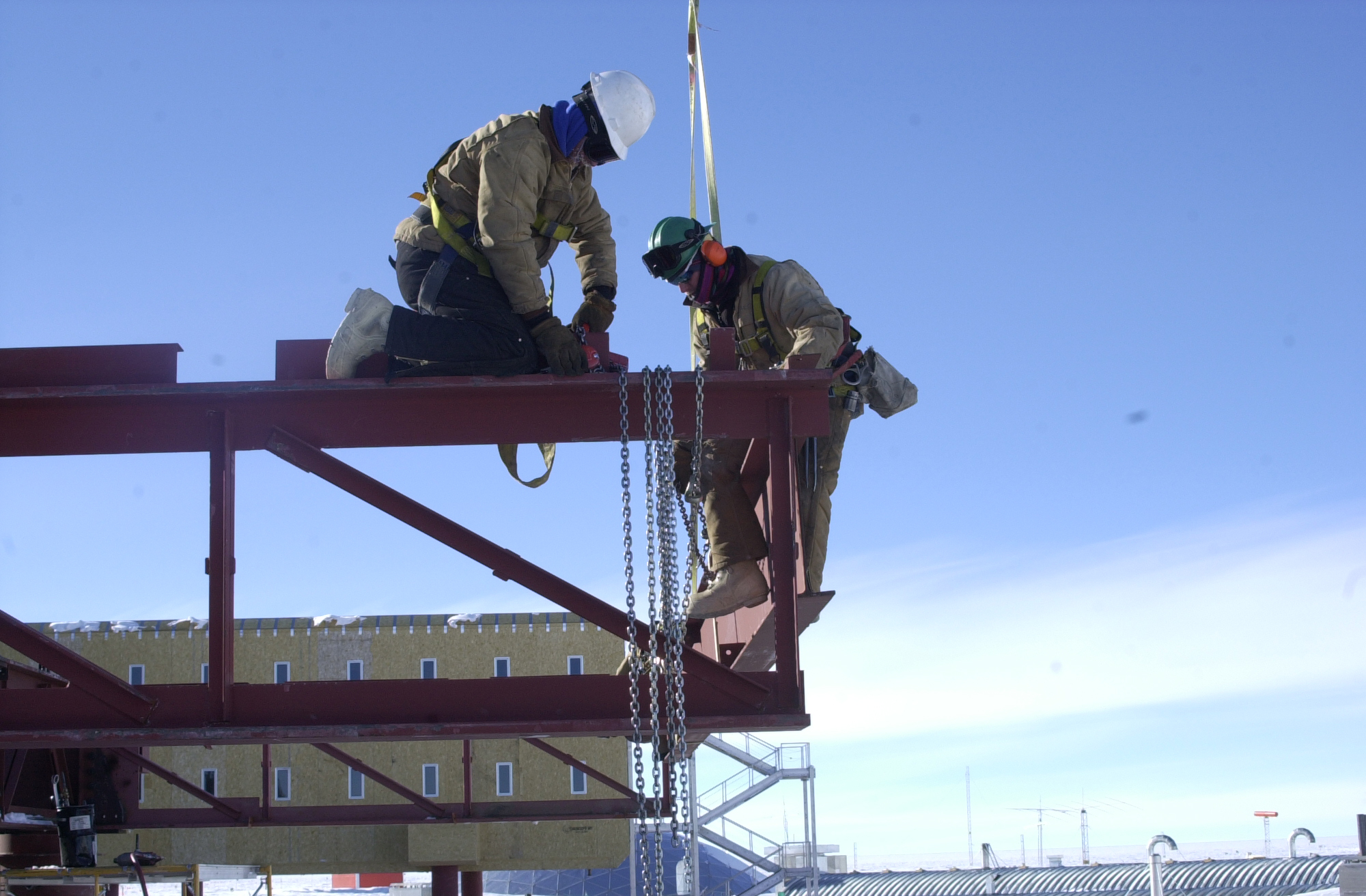 Men work on a steel beam.
