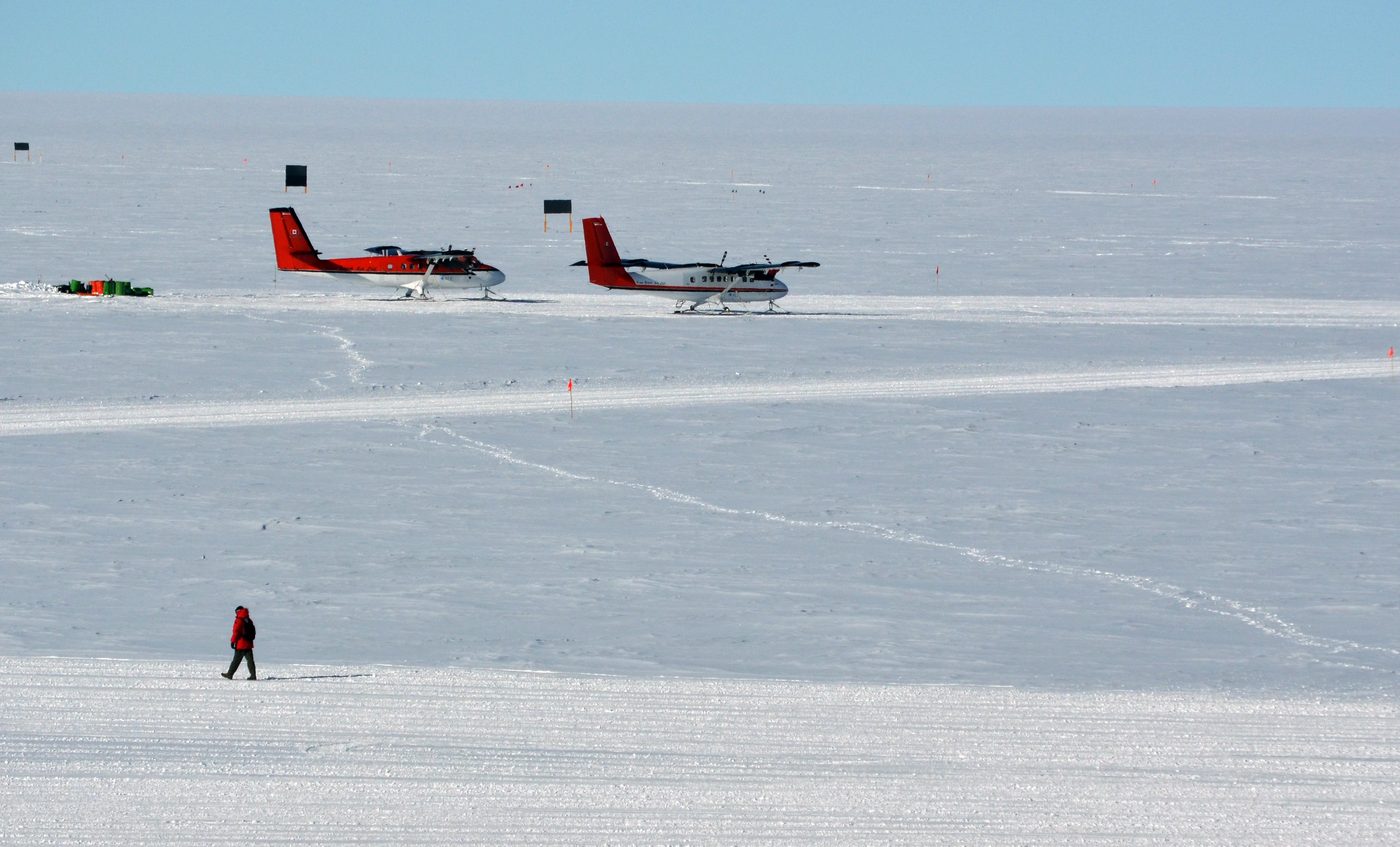 Two airplanes parked on snow.