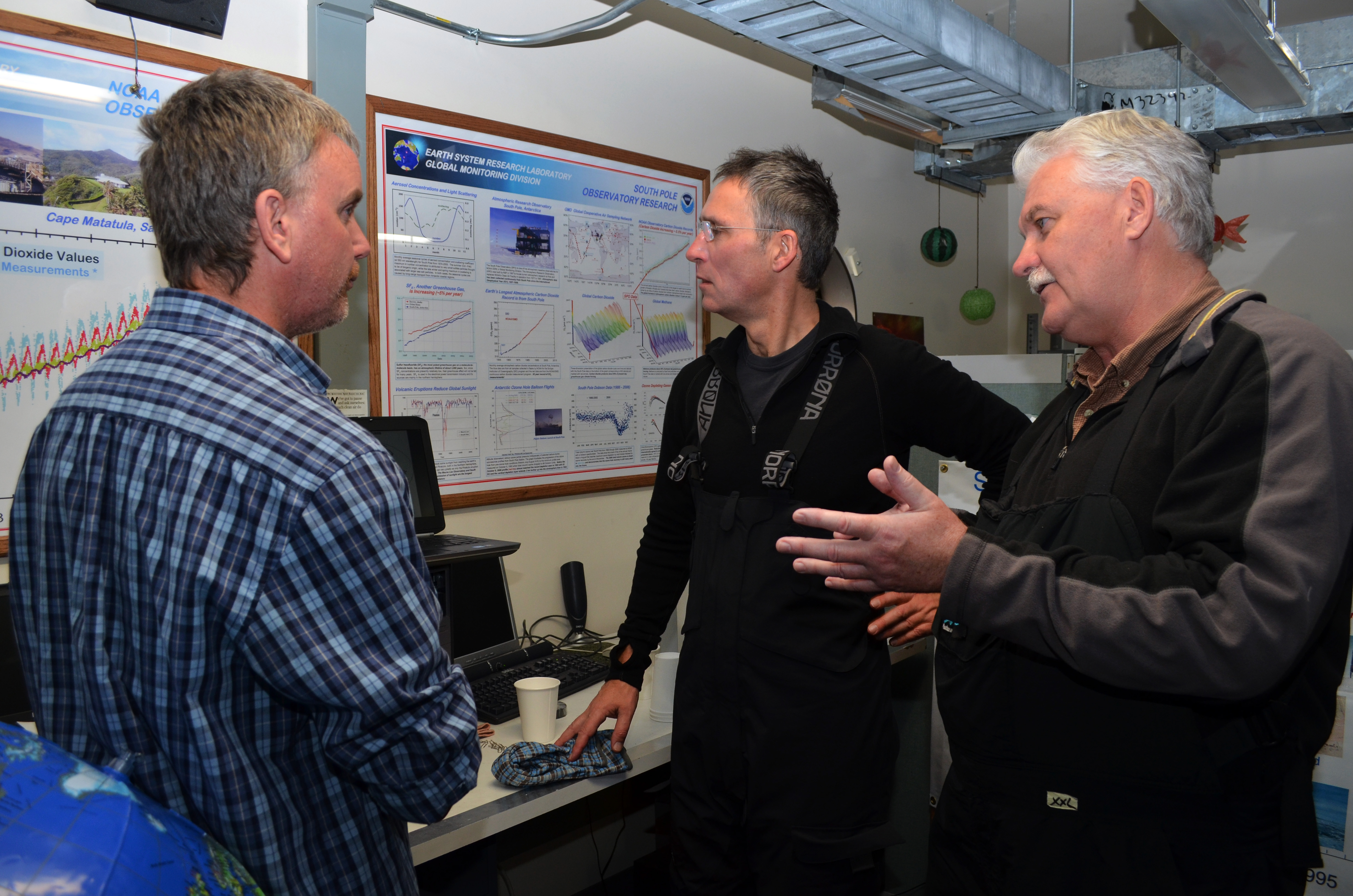 Three men in a science laboratory.