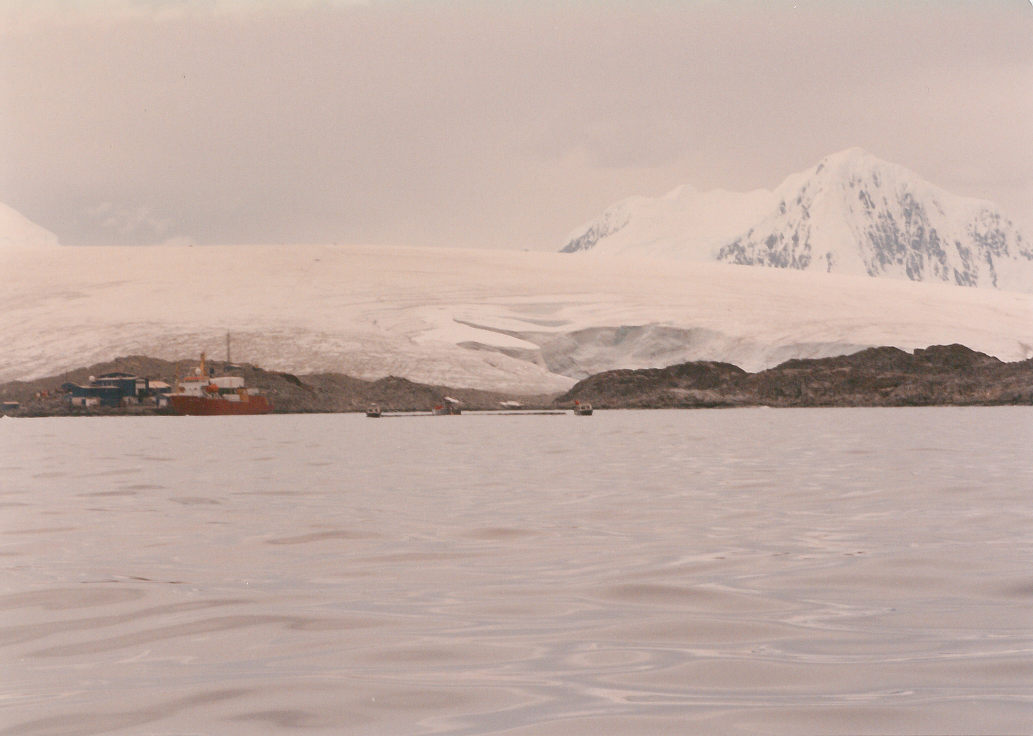 Open water, an island and snow-covered mountains in the distance.