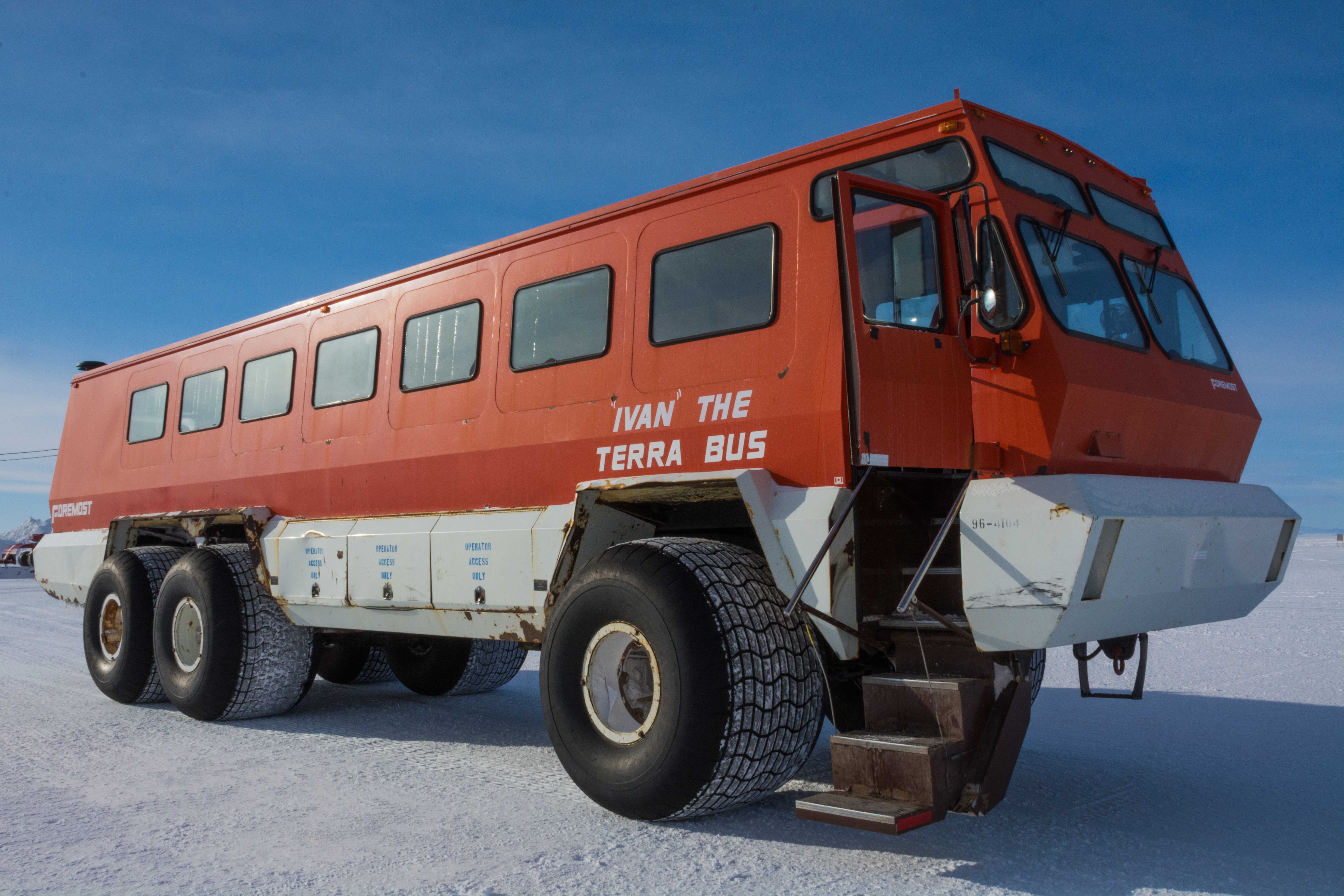 A red bus parked on the ice.