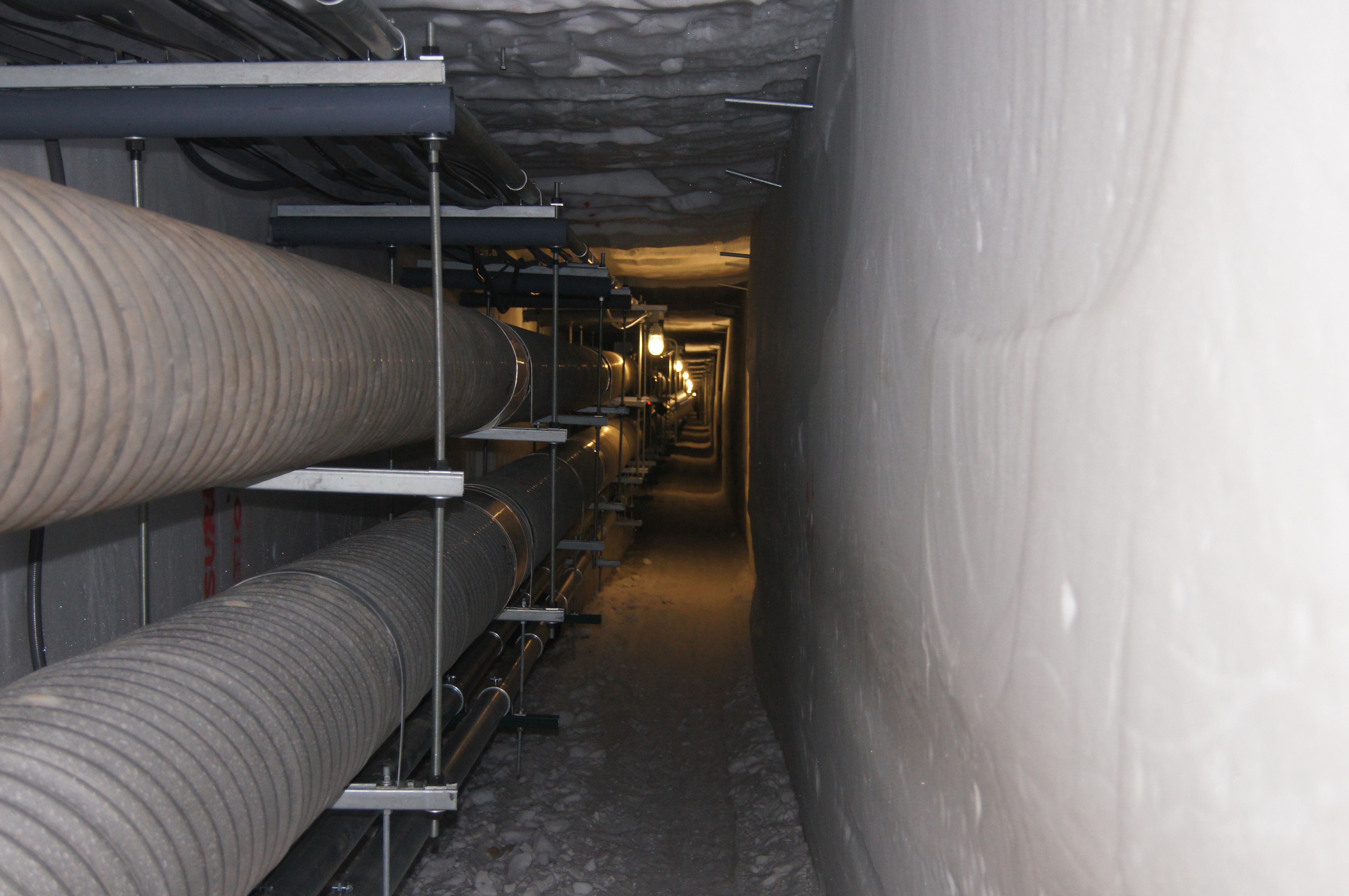 Utility pipes in an icy tunnel.