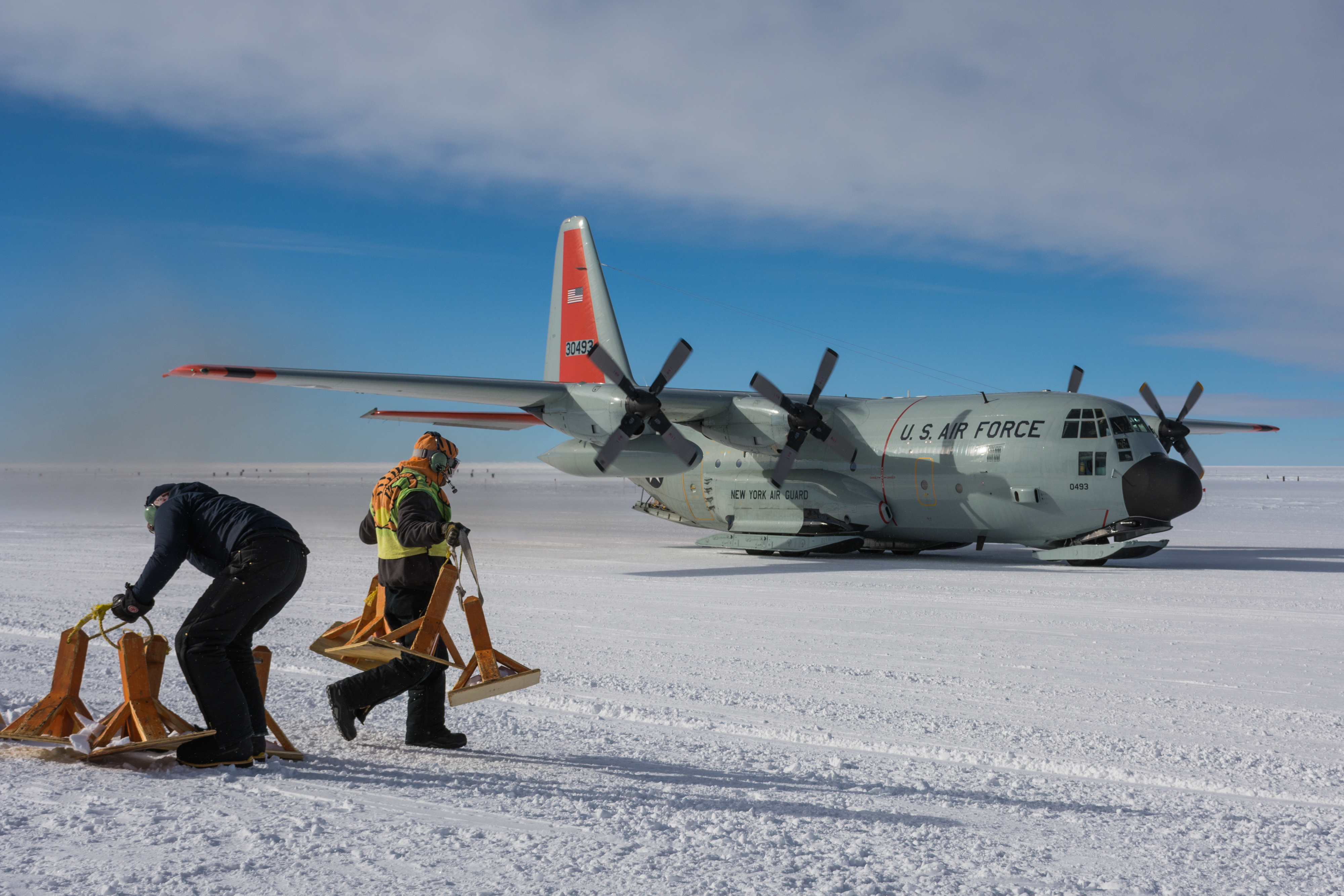 Two members of the ground crew in front of an airplane