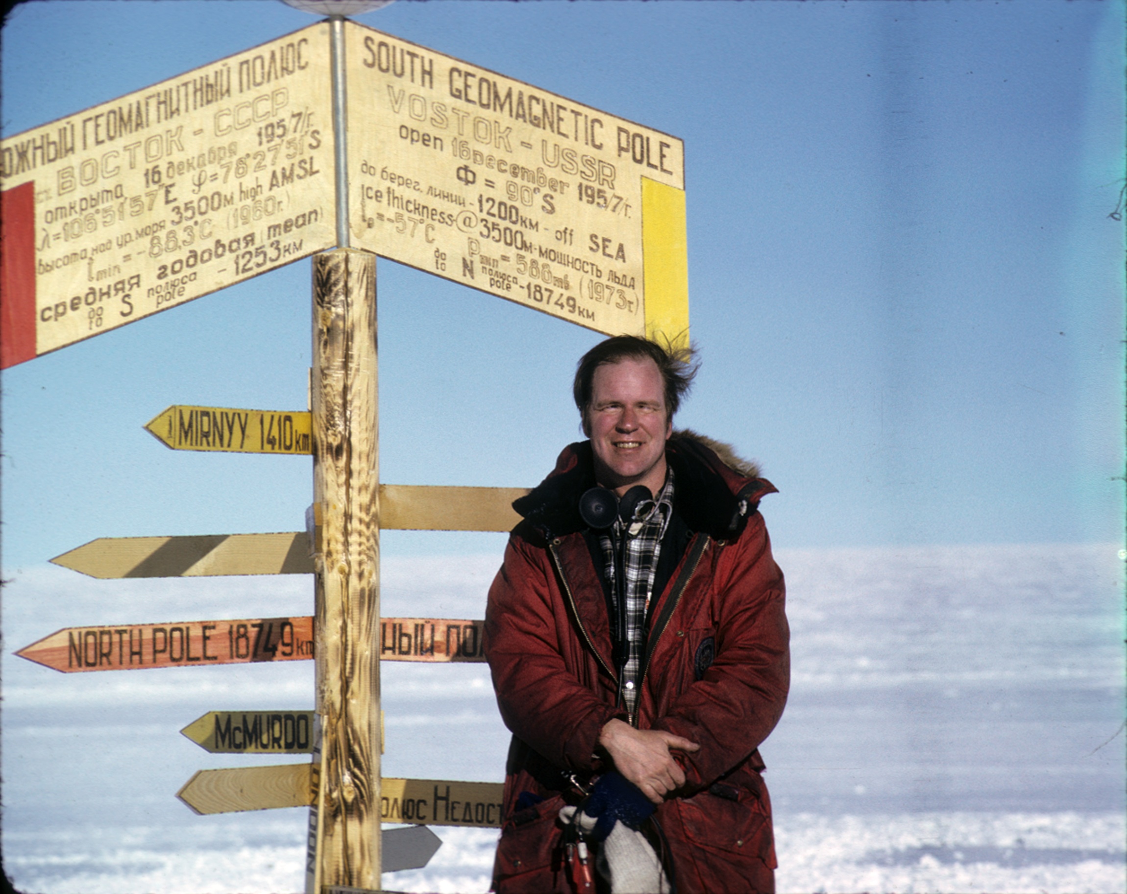 A man stands near a sign.