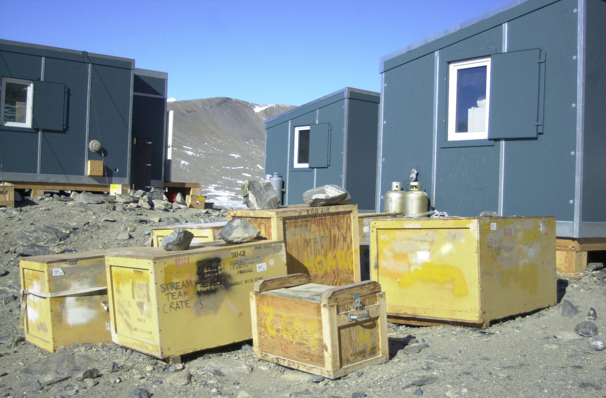 Several blue huts and wooden boxes.