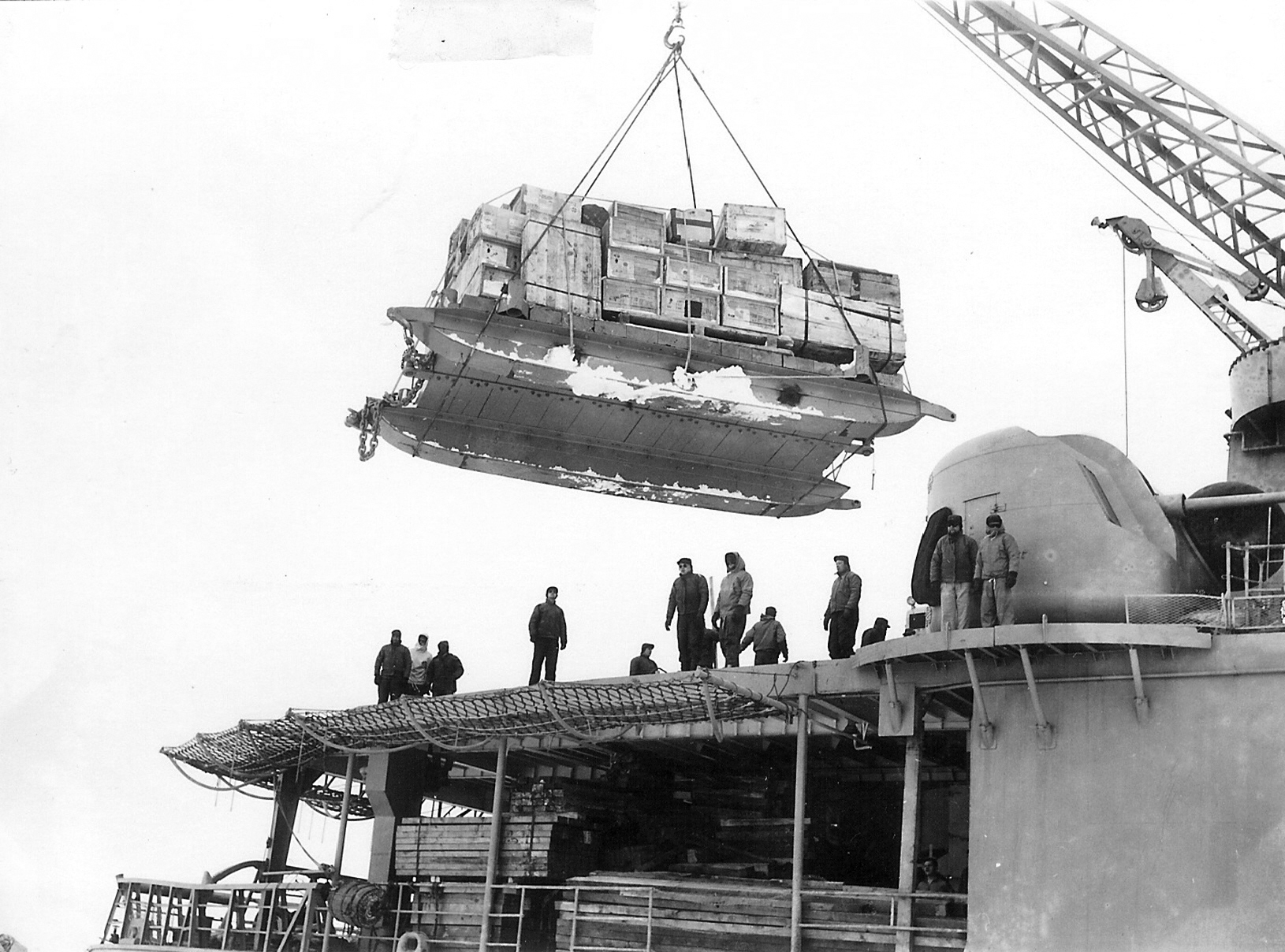 A crane lifts cargo off of a ship.