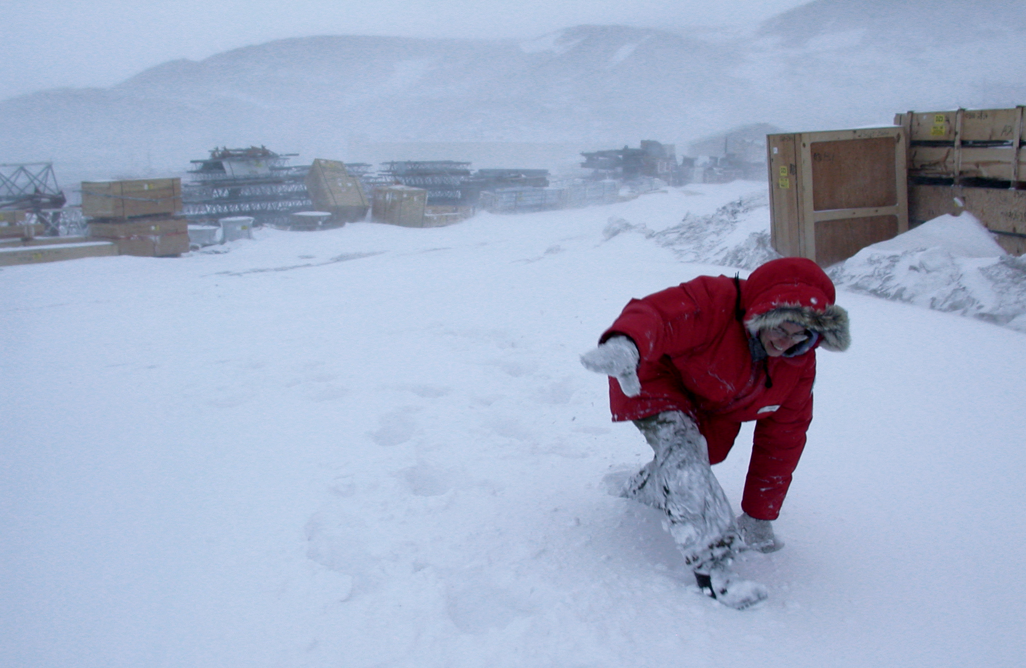 A woman walks through deep snow drifts.