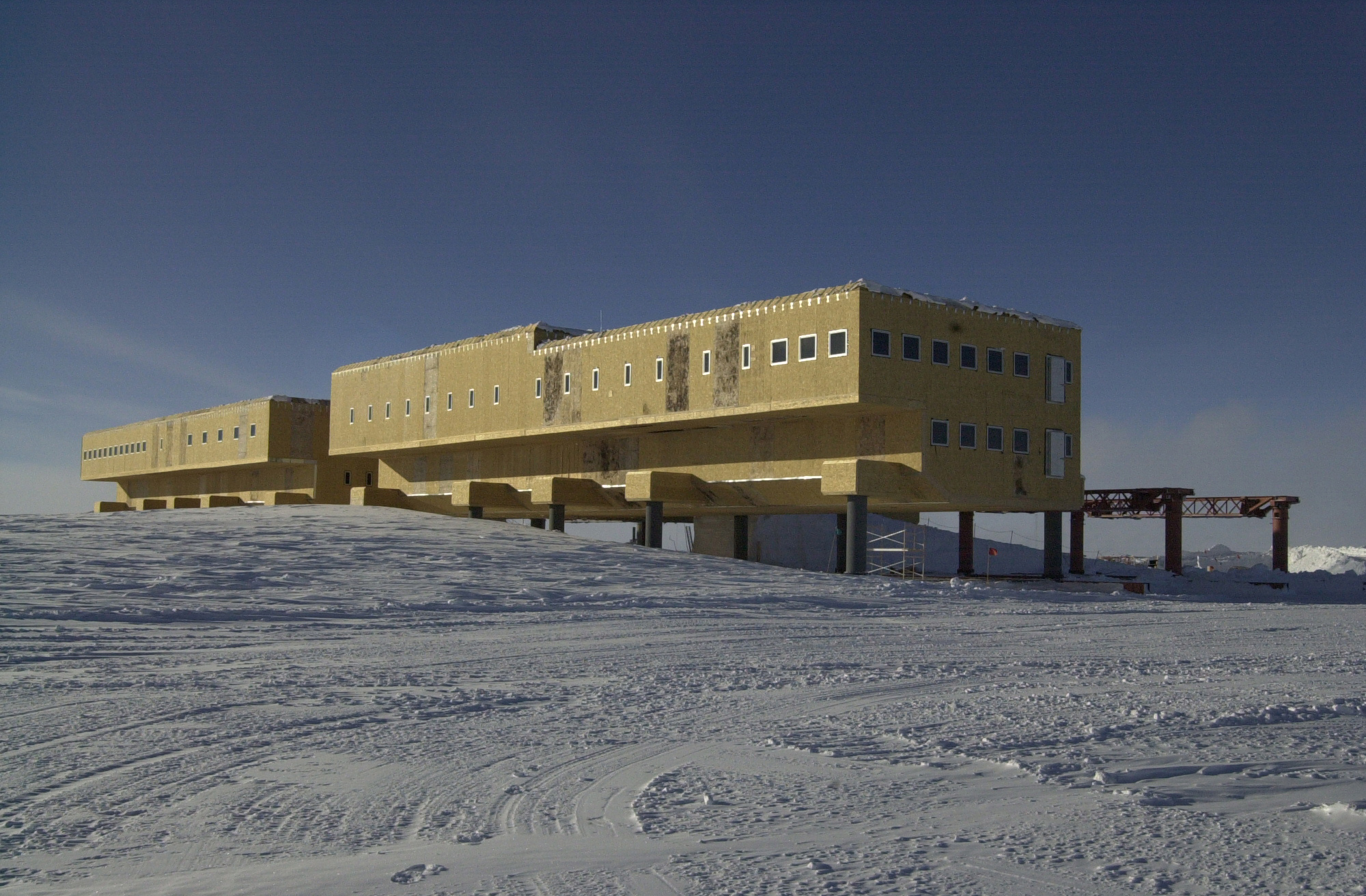 A rectangular building with stilts on the snow.