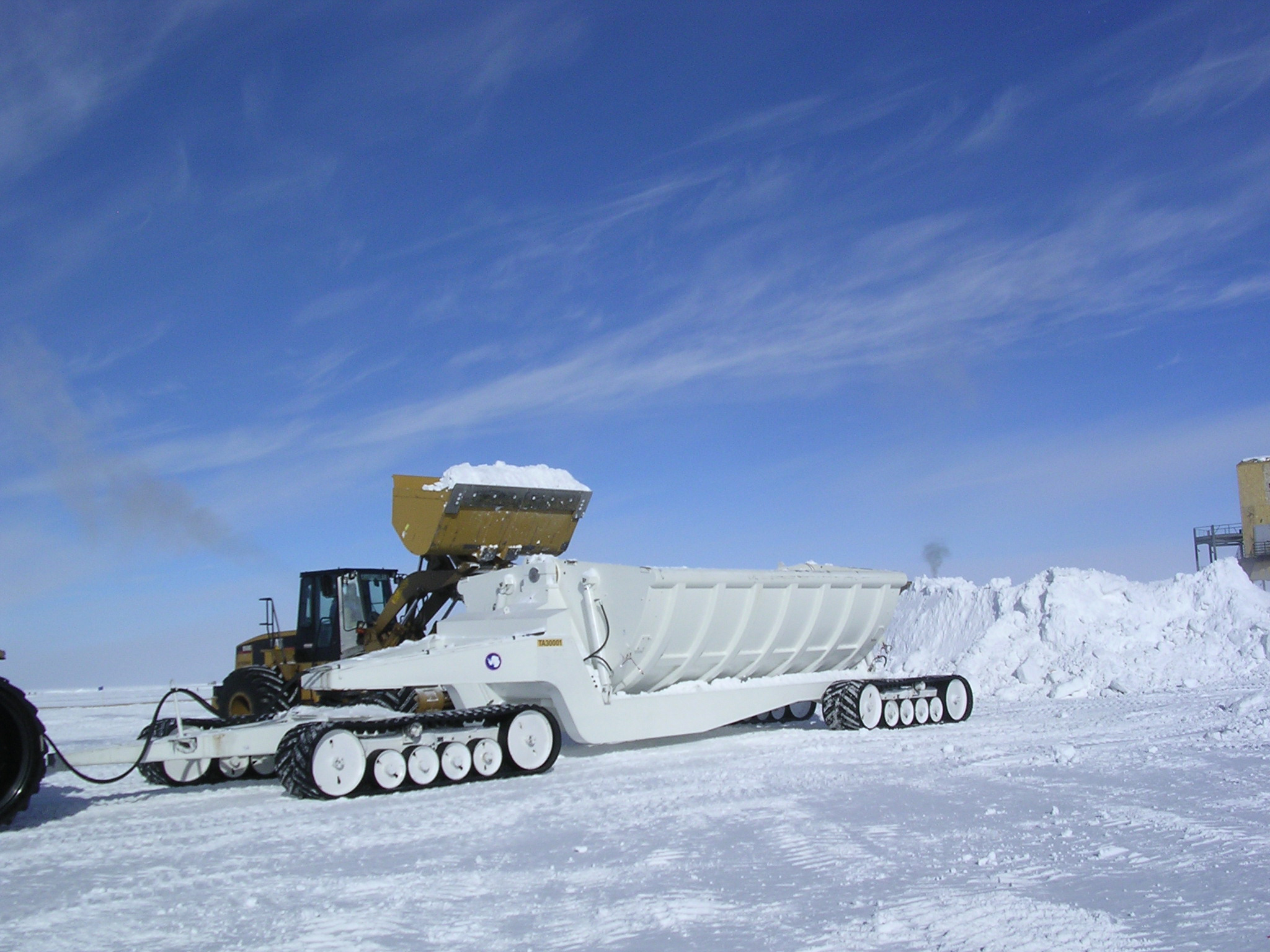 Dumping snow into a truck.