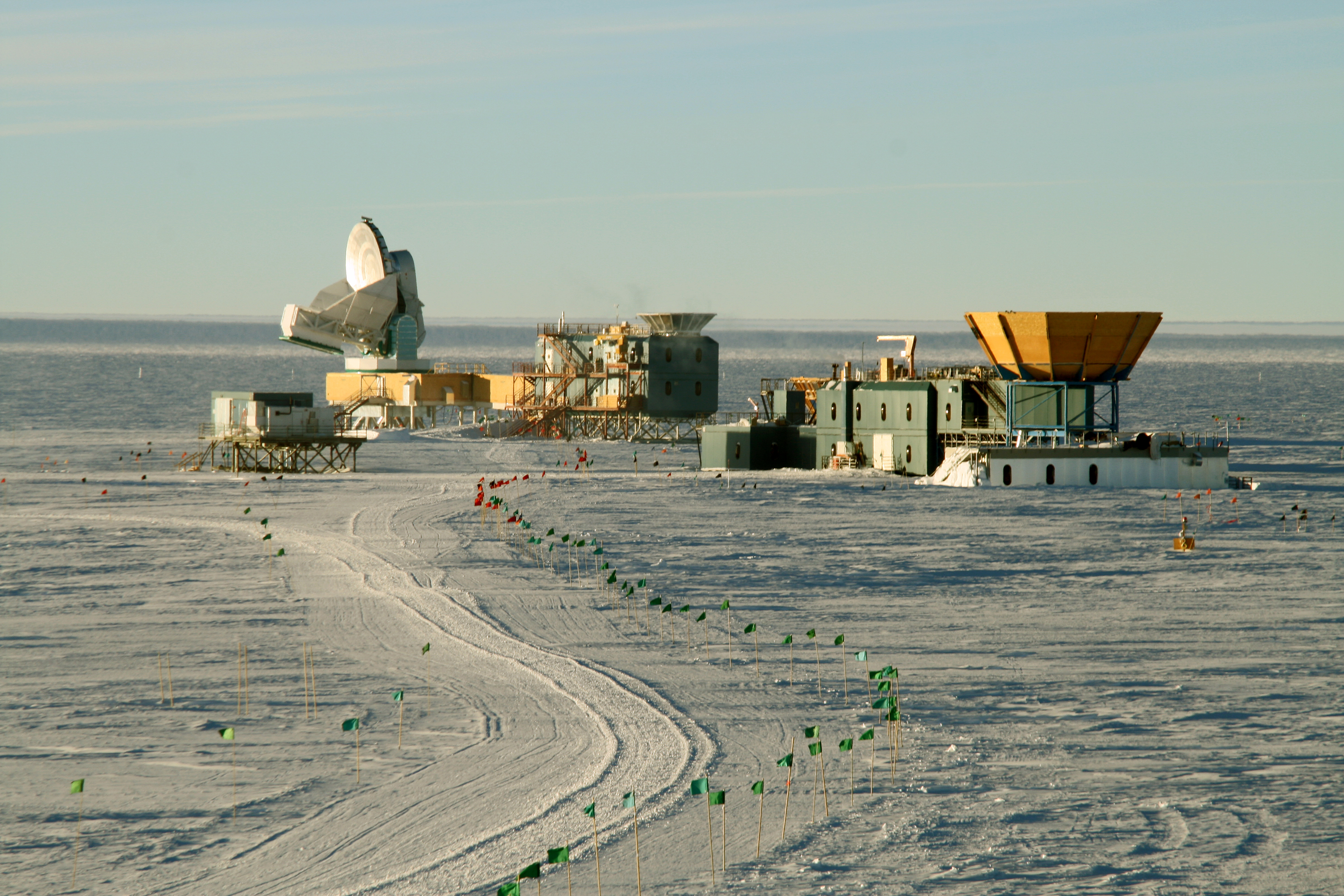 A line of flags leads to a cluster of buildings.