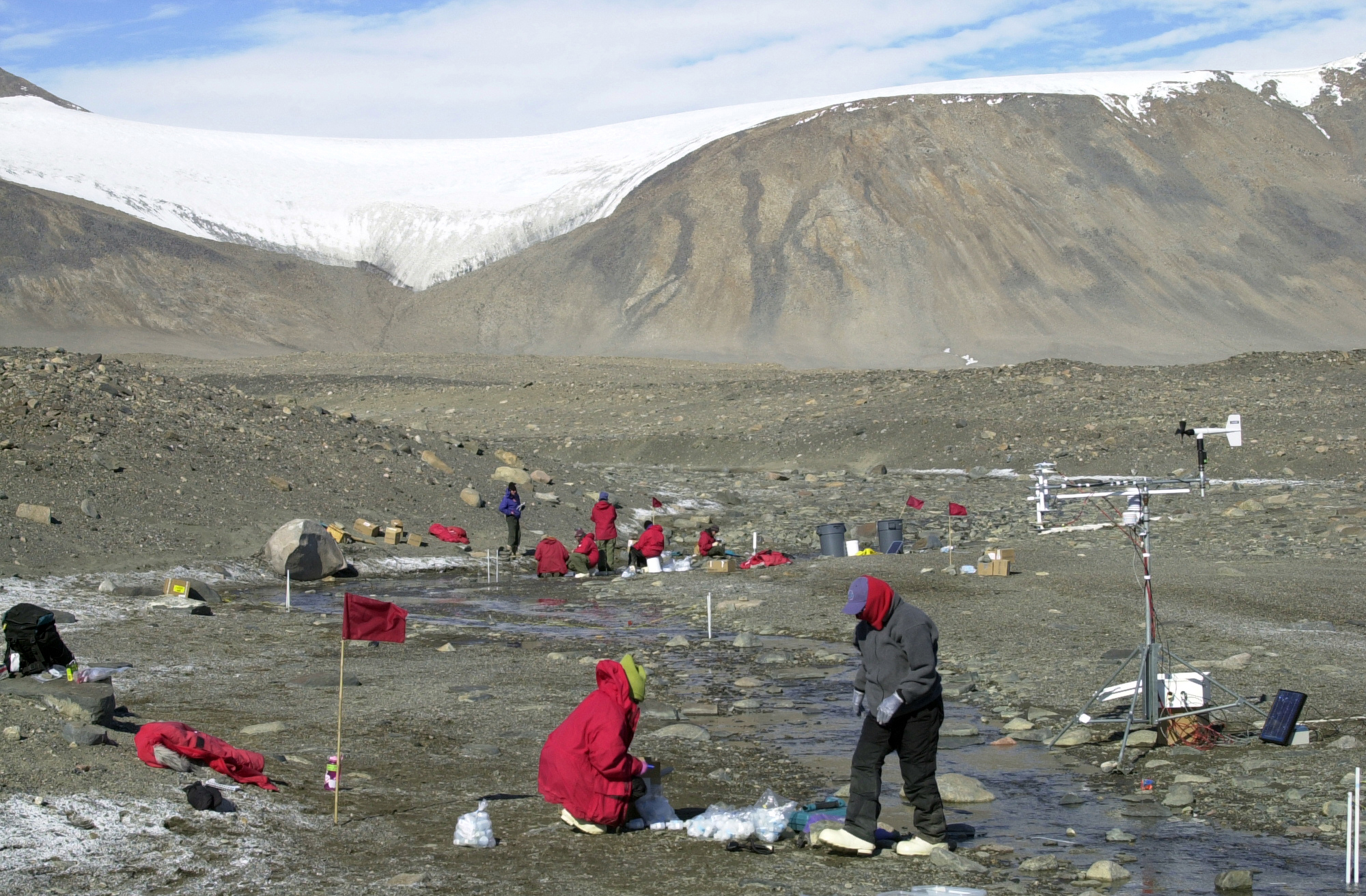 People stand along a stream.