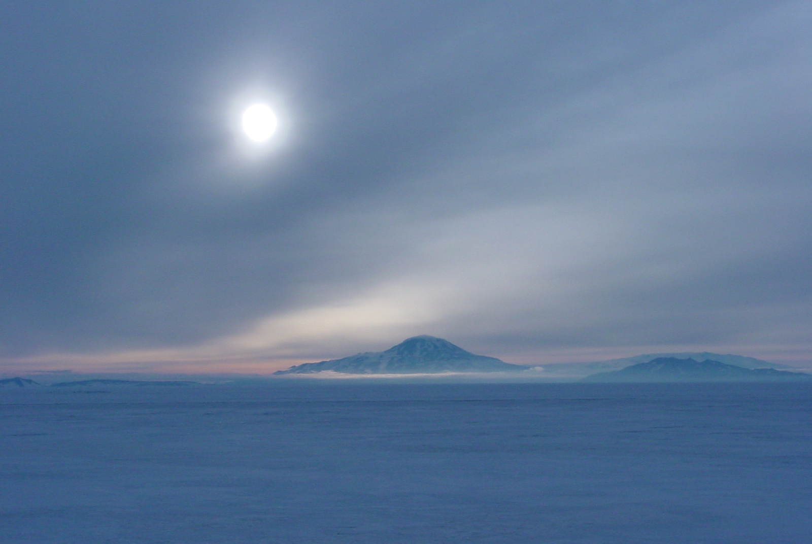 The sun shines over a mountain.