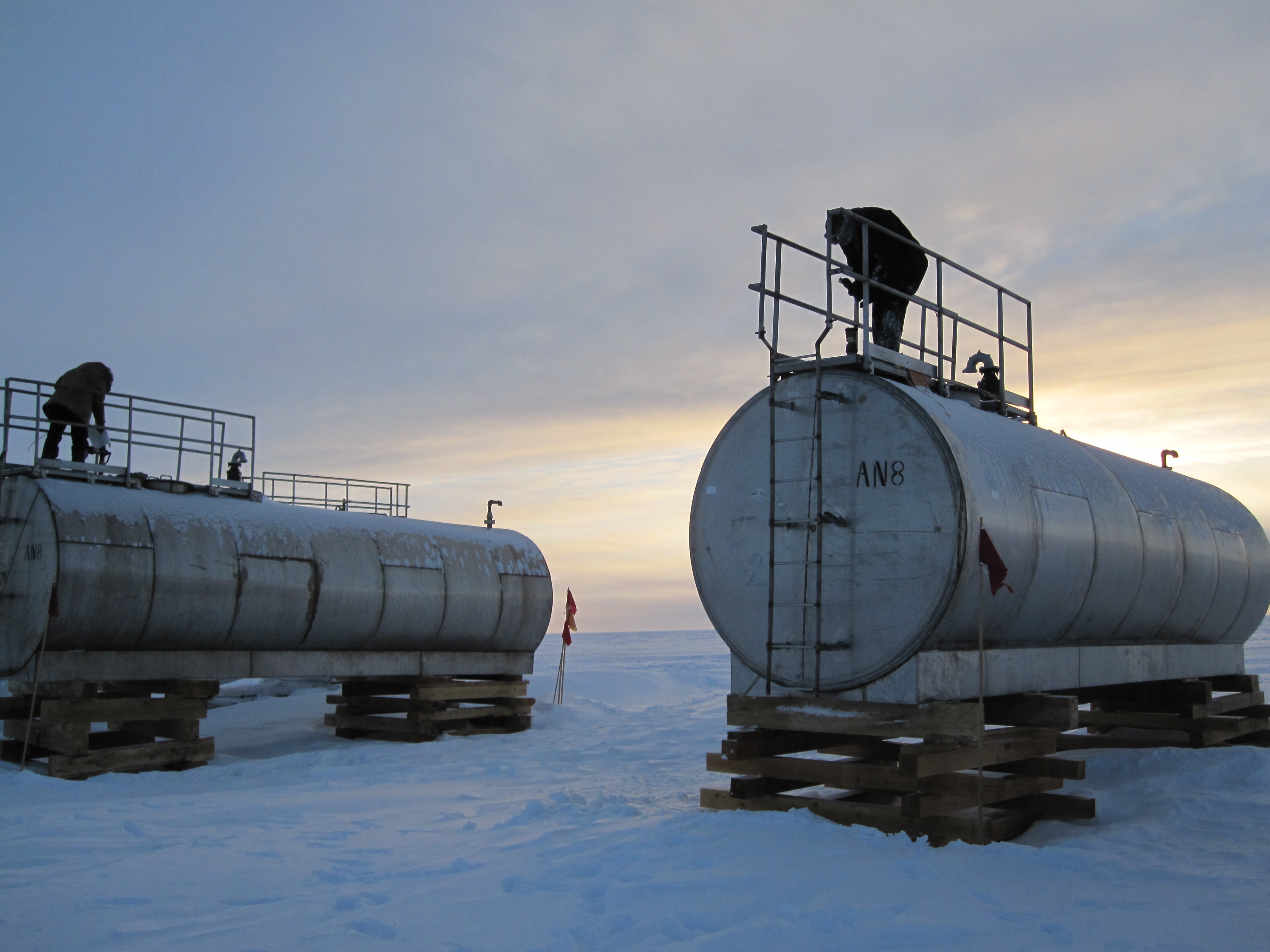 People on top of a fuel tank.