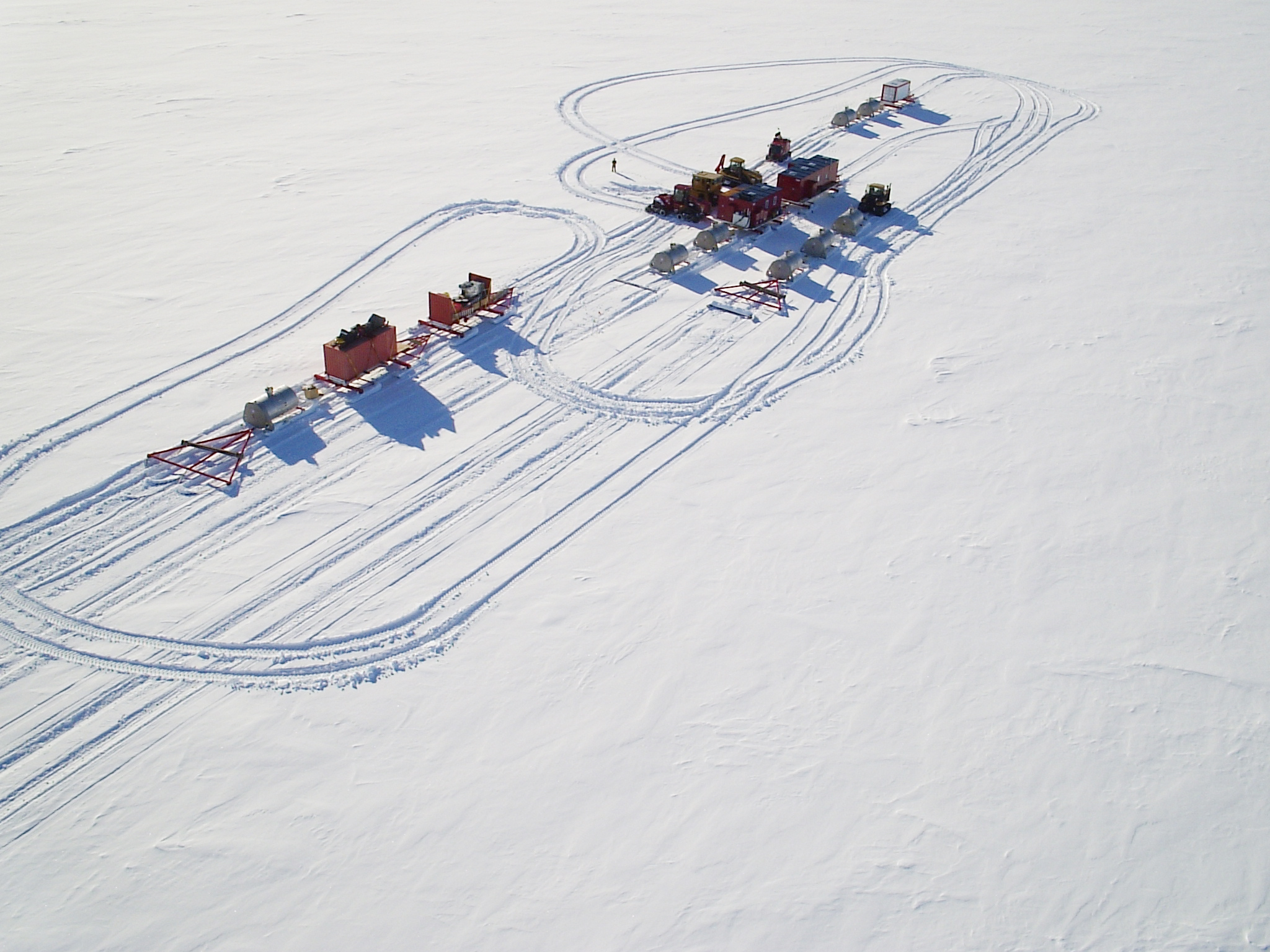 Tractors with large sleds on snow.