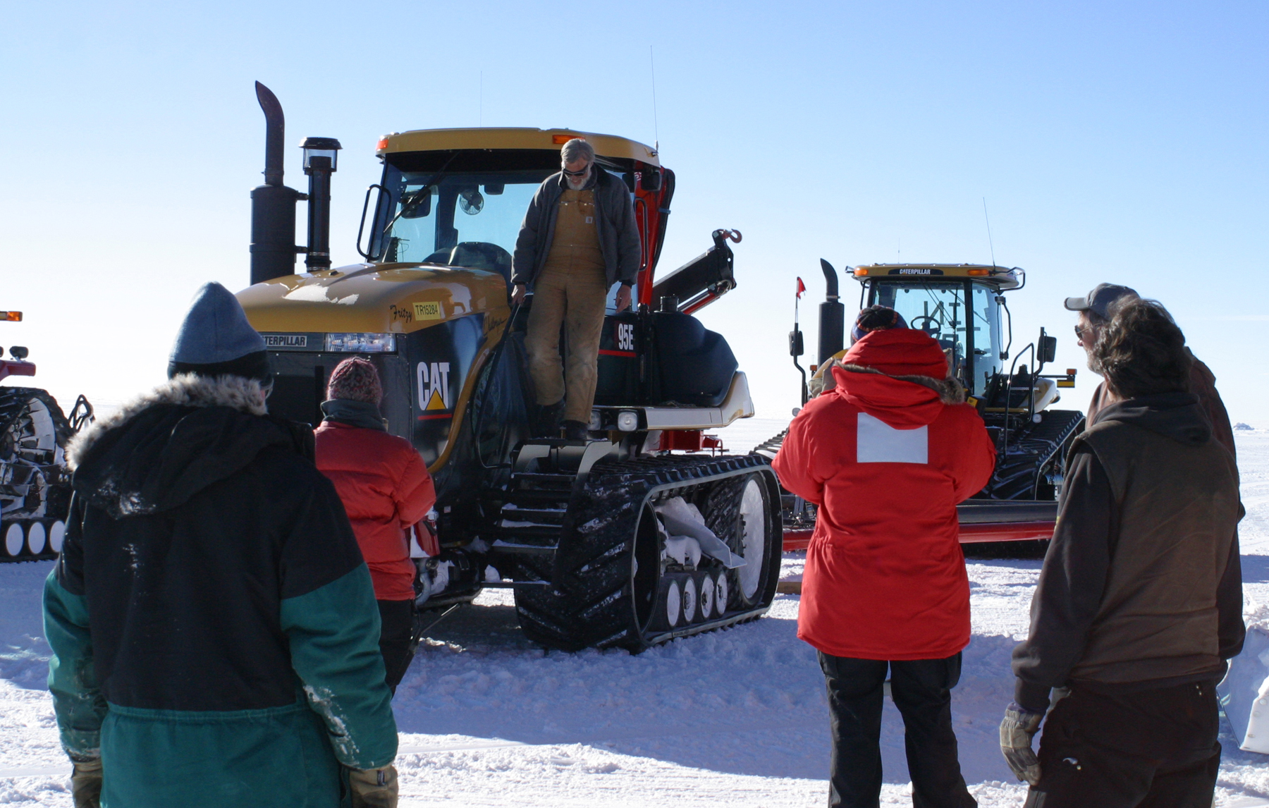 A man steps down from a tractor.