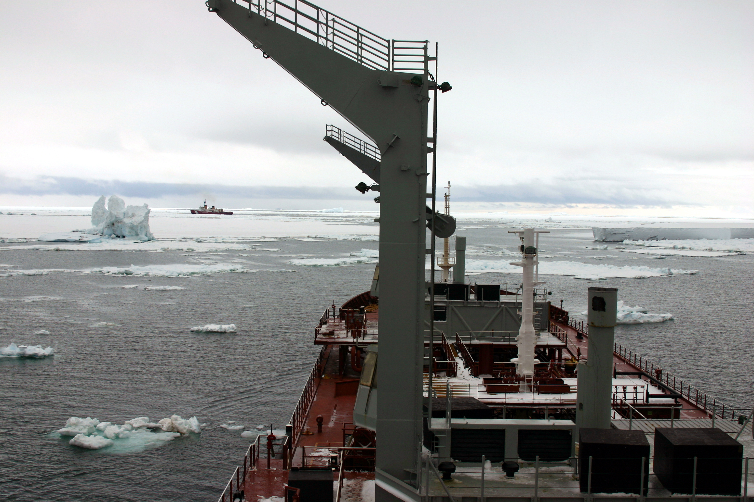 A ship in sea ice with another ship in the distance.