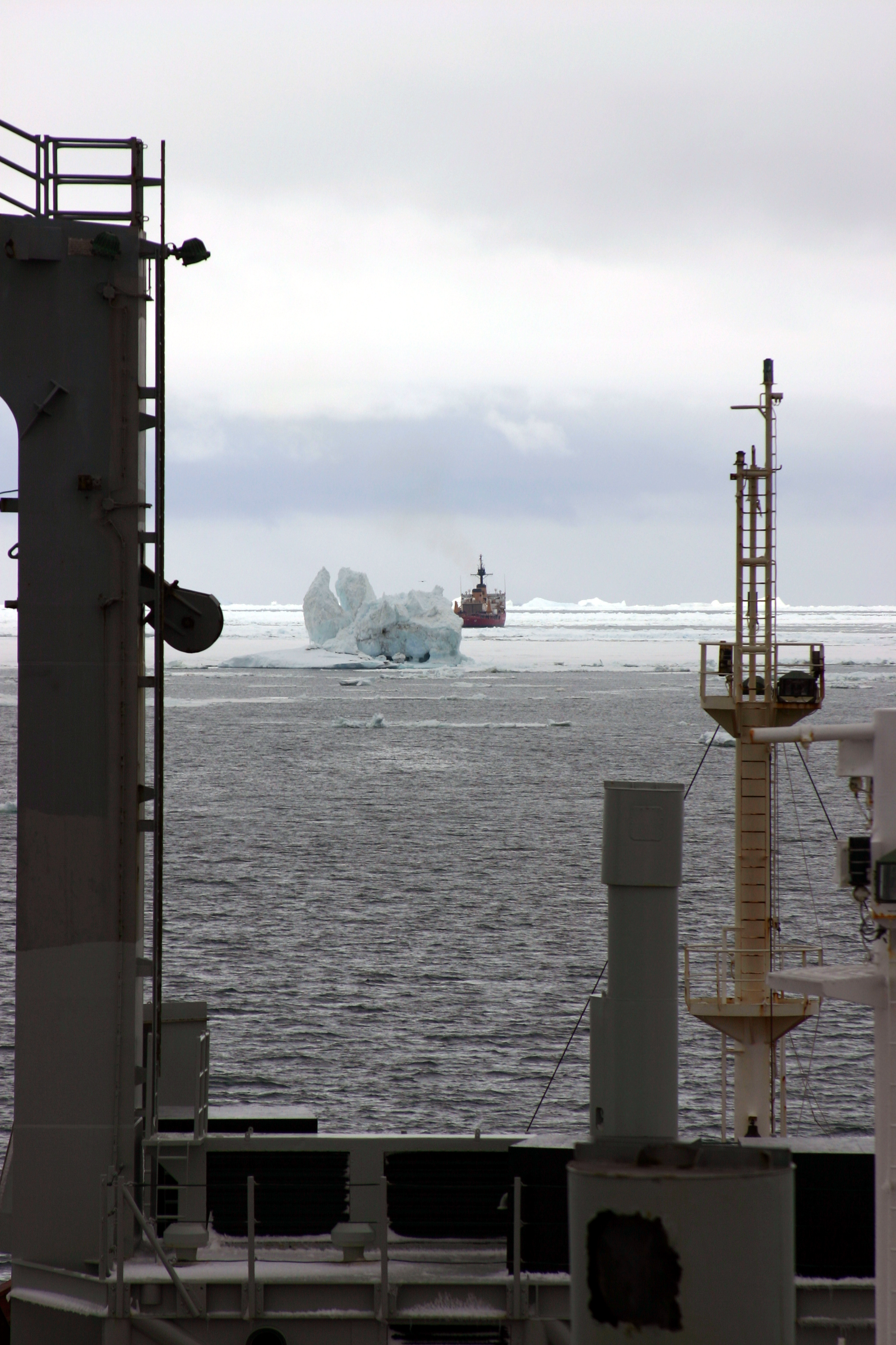 A ship in sea ice with another ship in the distance.