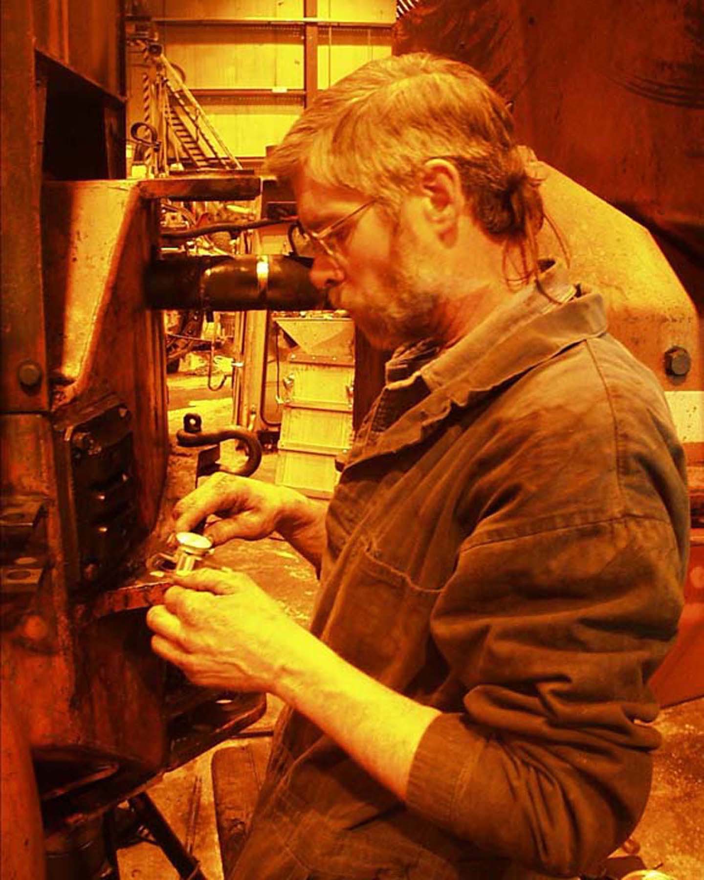 A mechanic works on a machine.