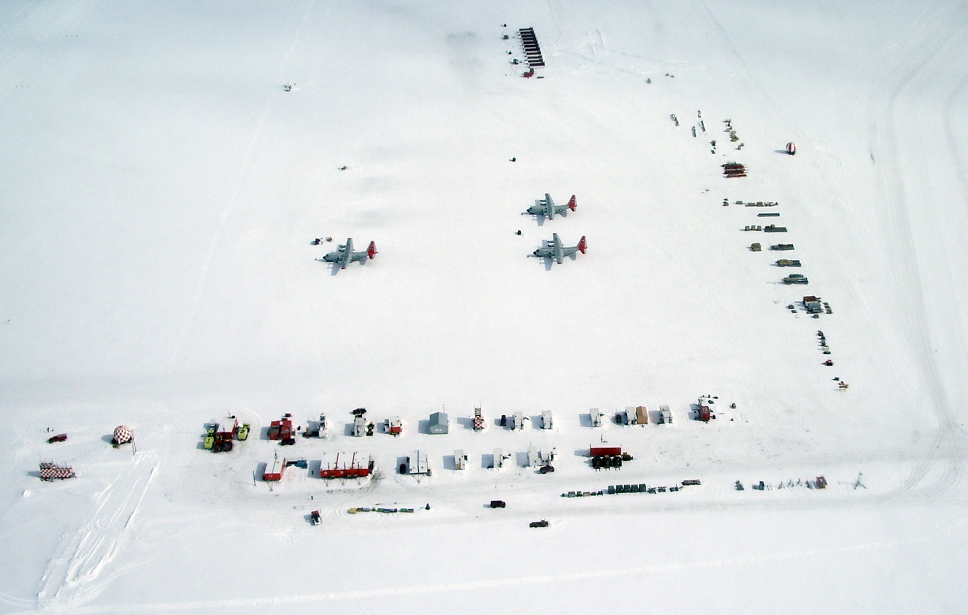 Aerial view of airplanes and a building.