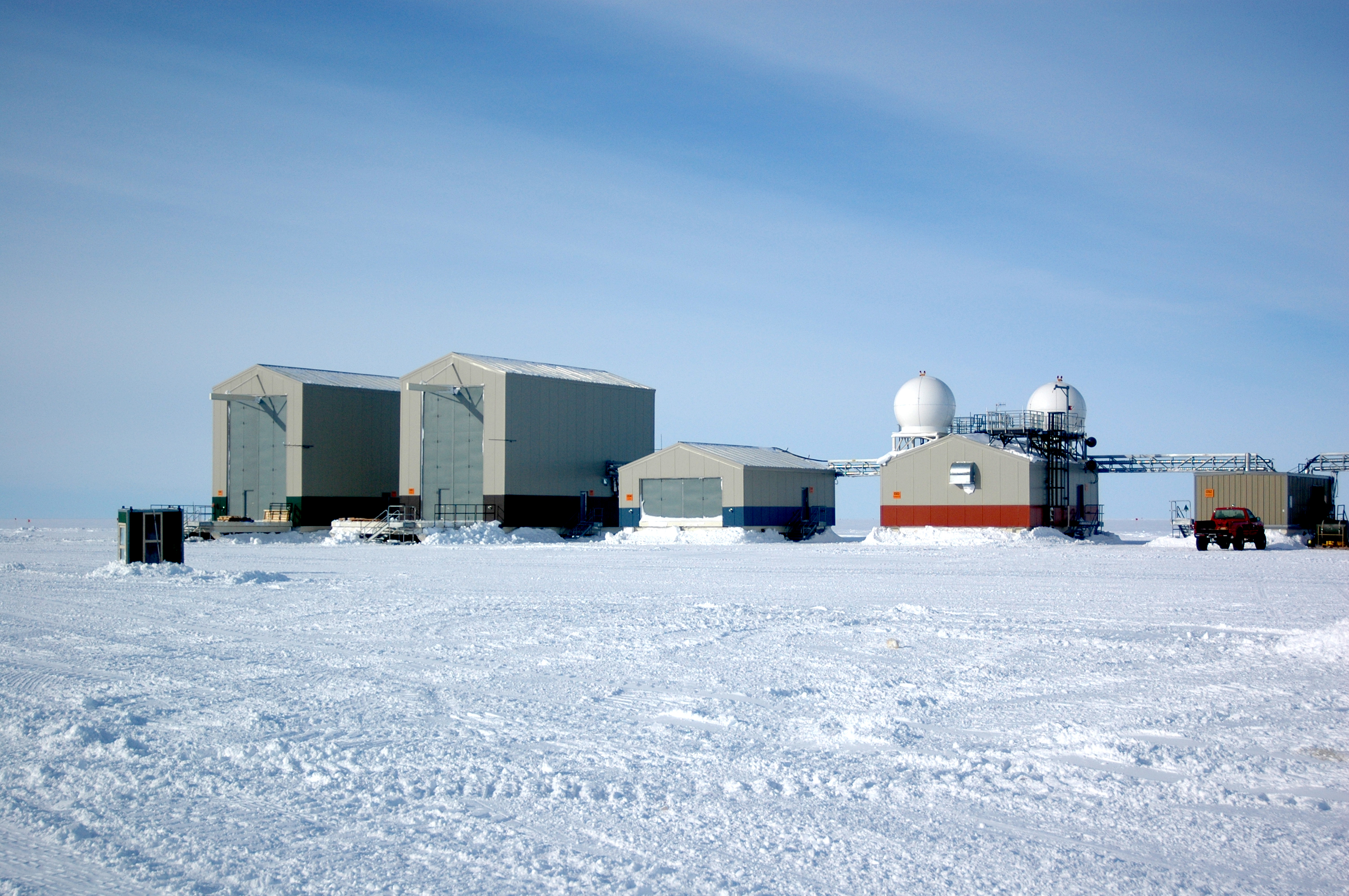 A row of buildings sit on snowy surface.