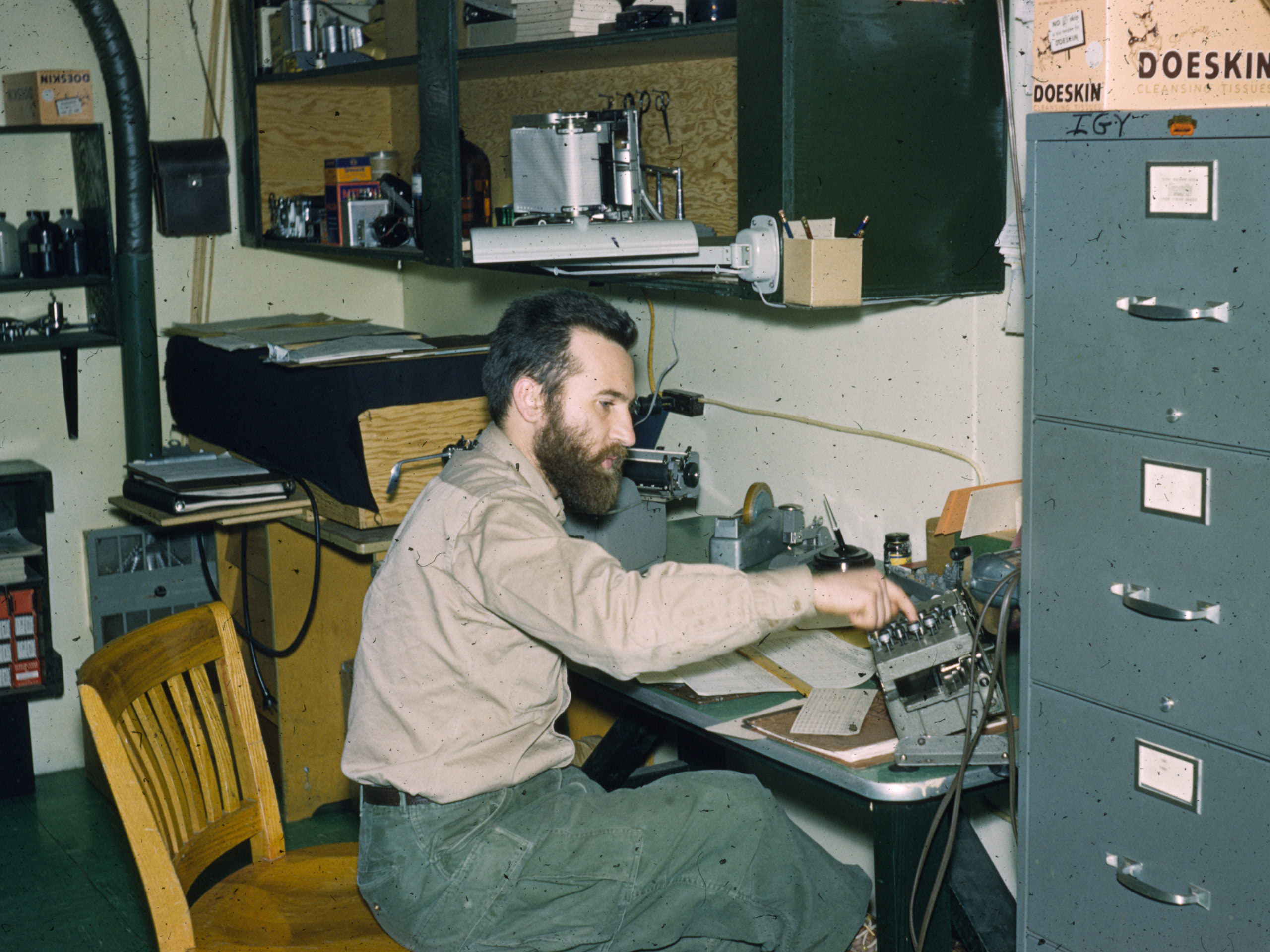 A man works on a machine in an office.