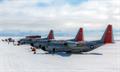 Three planes sit idle on the ice.