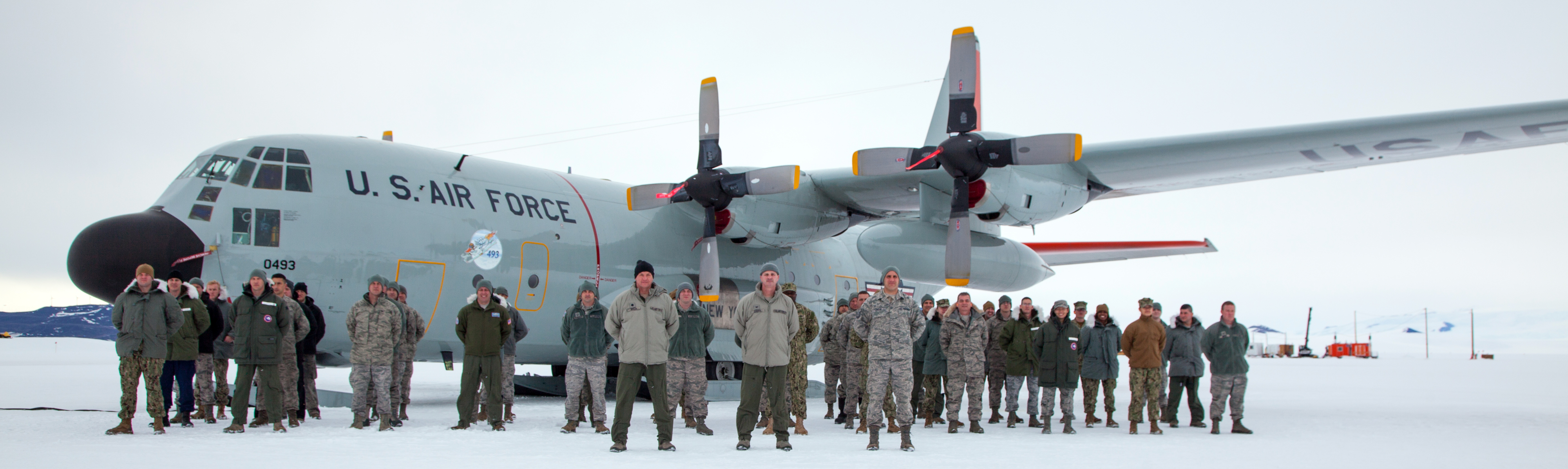 People stand in formation in front of an airplane.