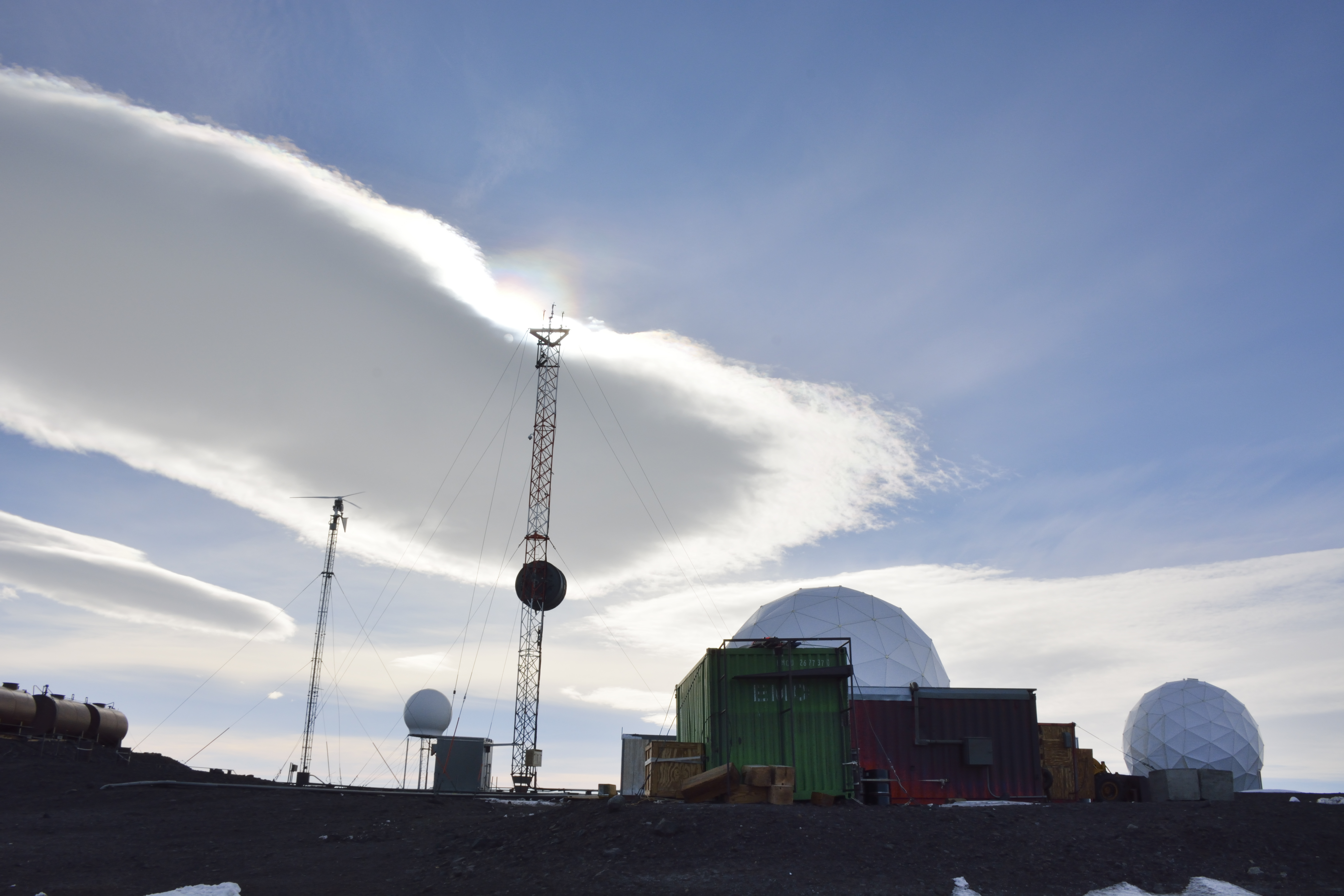 Clouds cover a small cluster of buildings used for telecommunications.