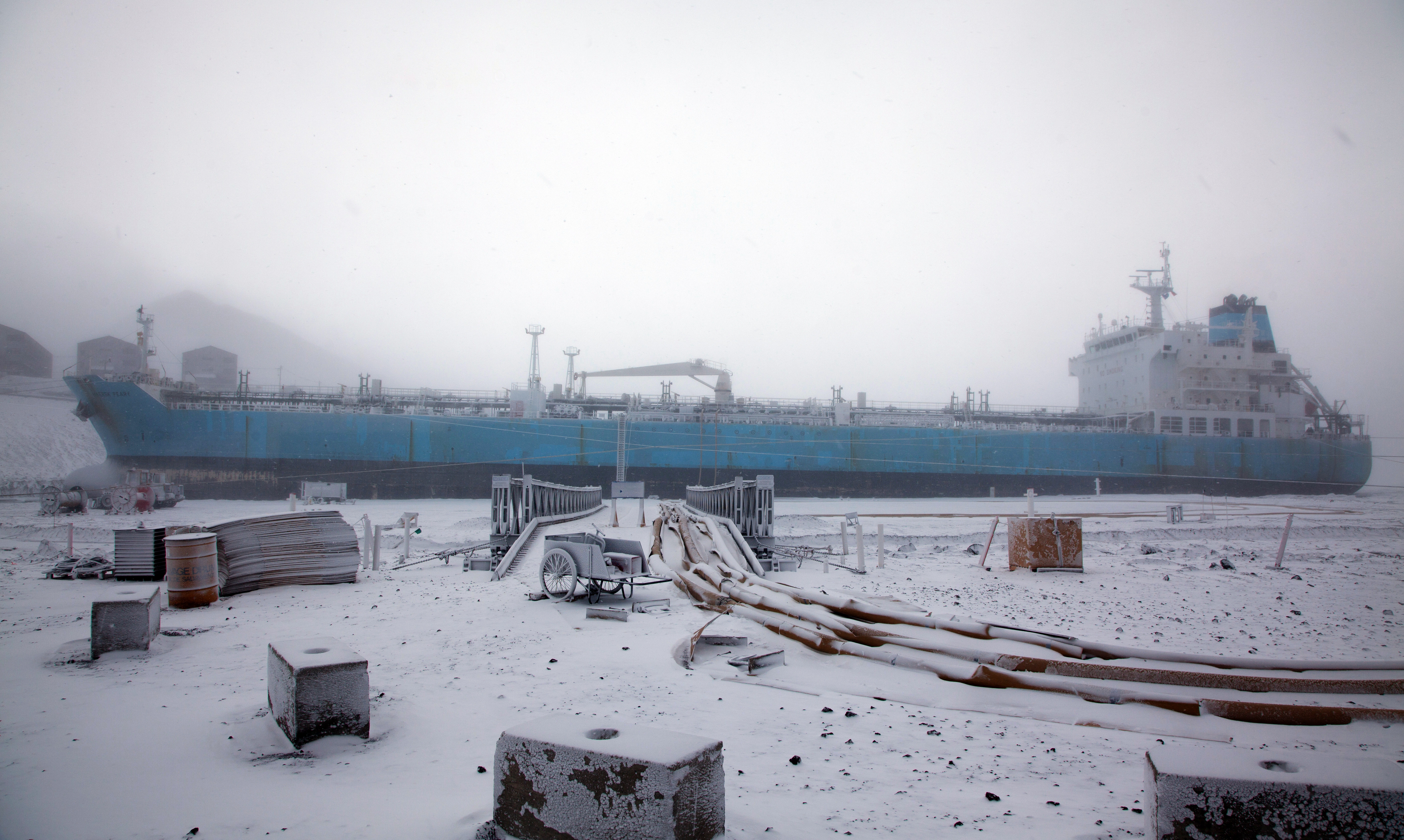 Fog partly obscures a large ship.