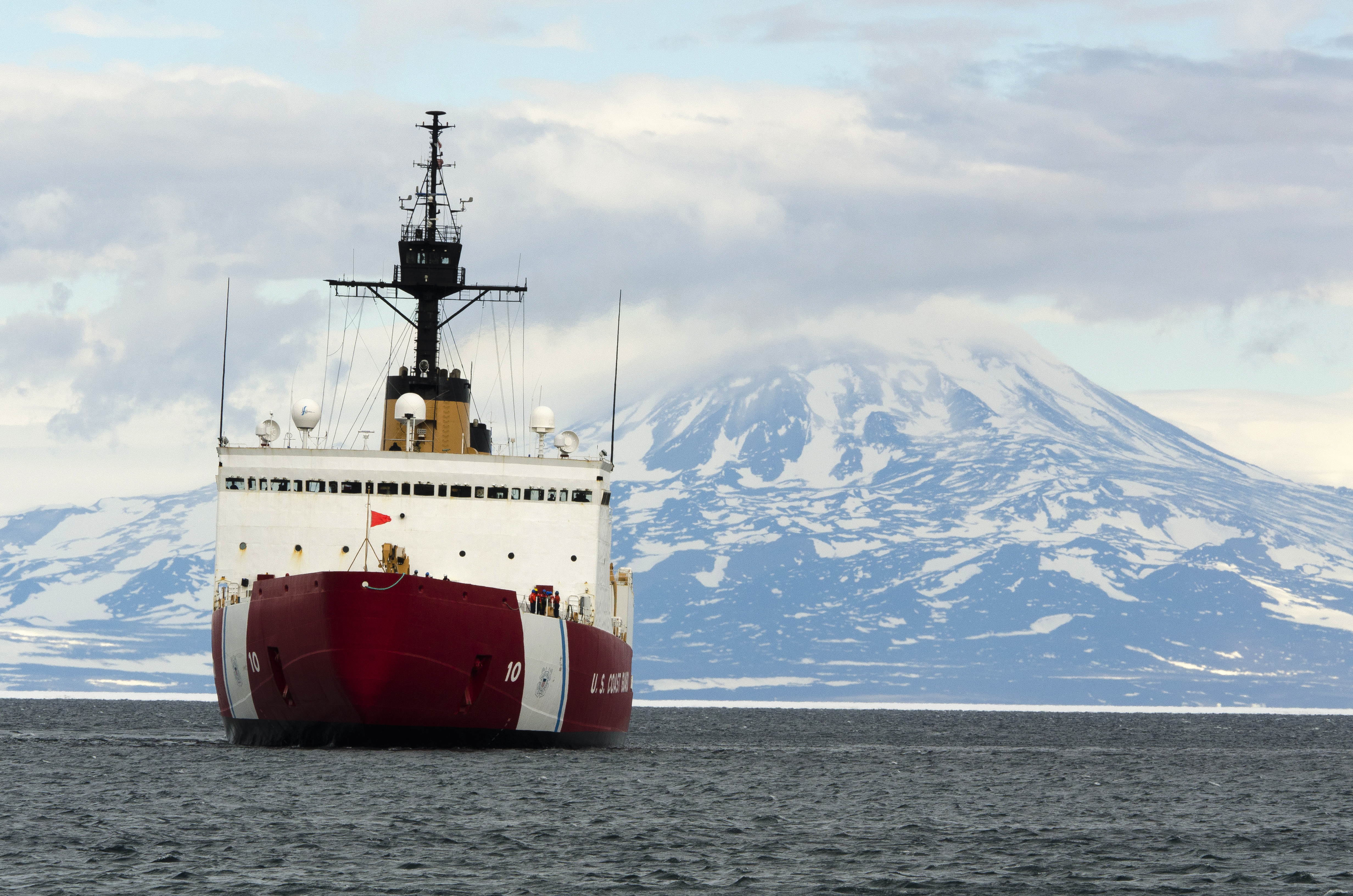 Ship in sea with mountain in distance.