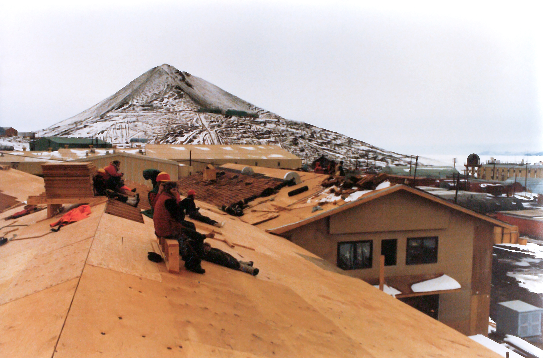 Construction workers  sitting on a roof.