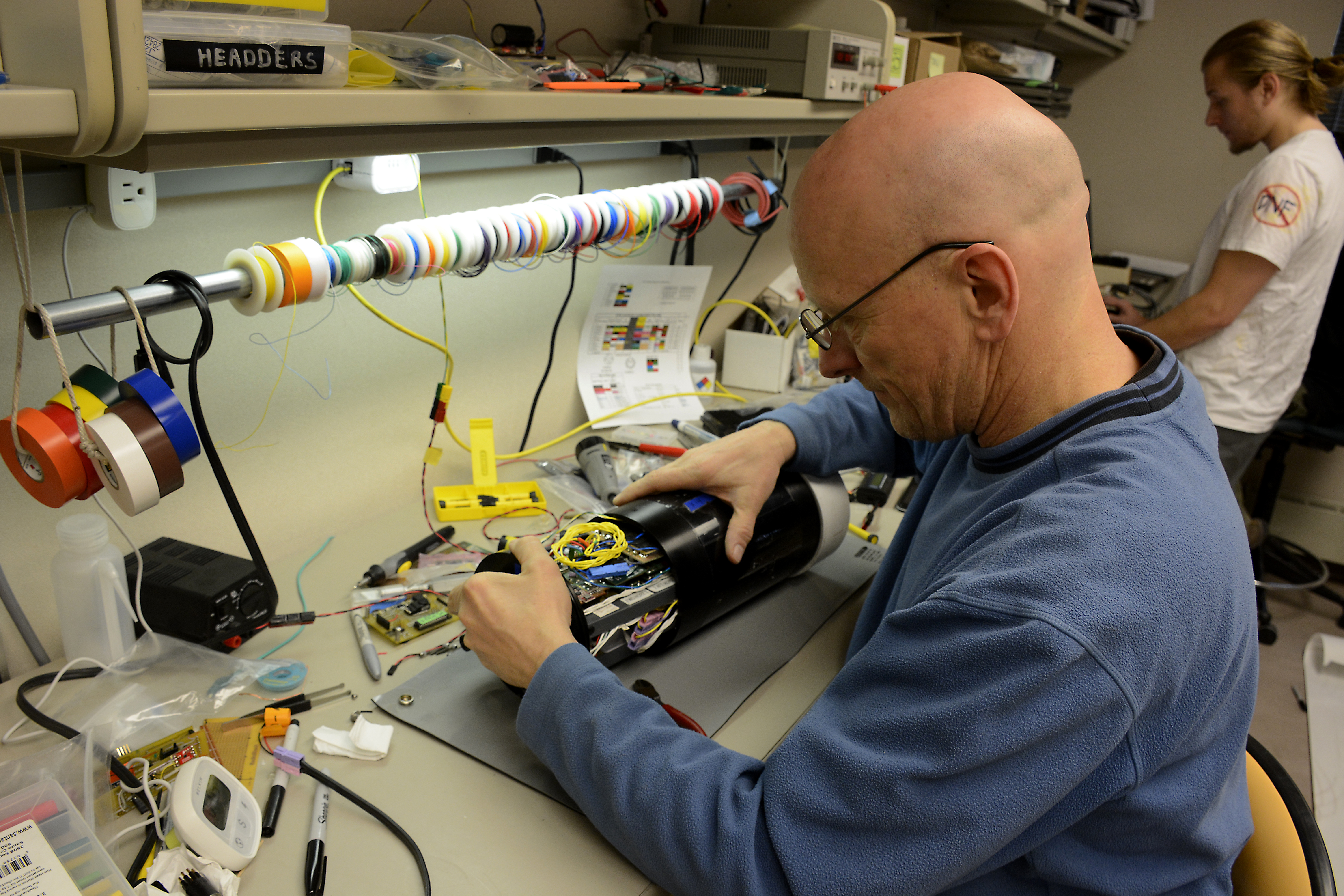 Person works on electronics at a desk.