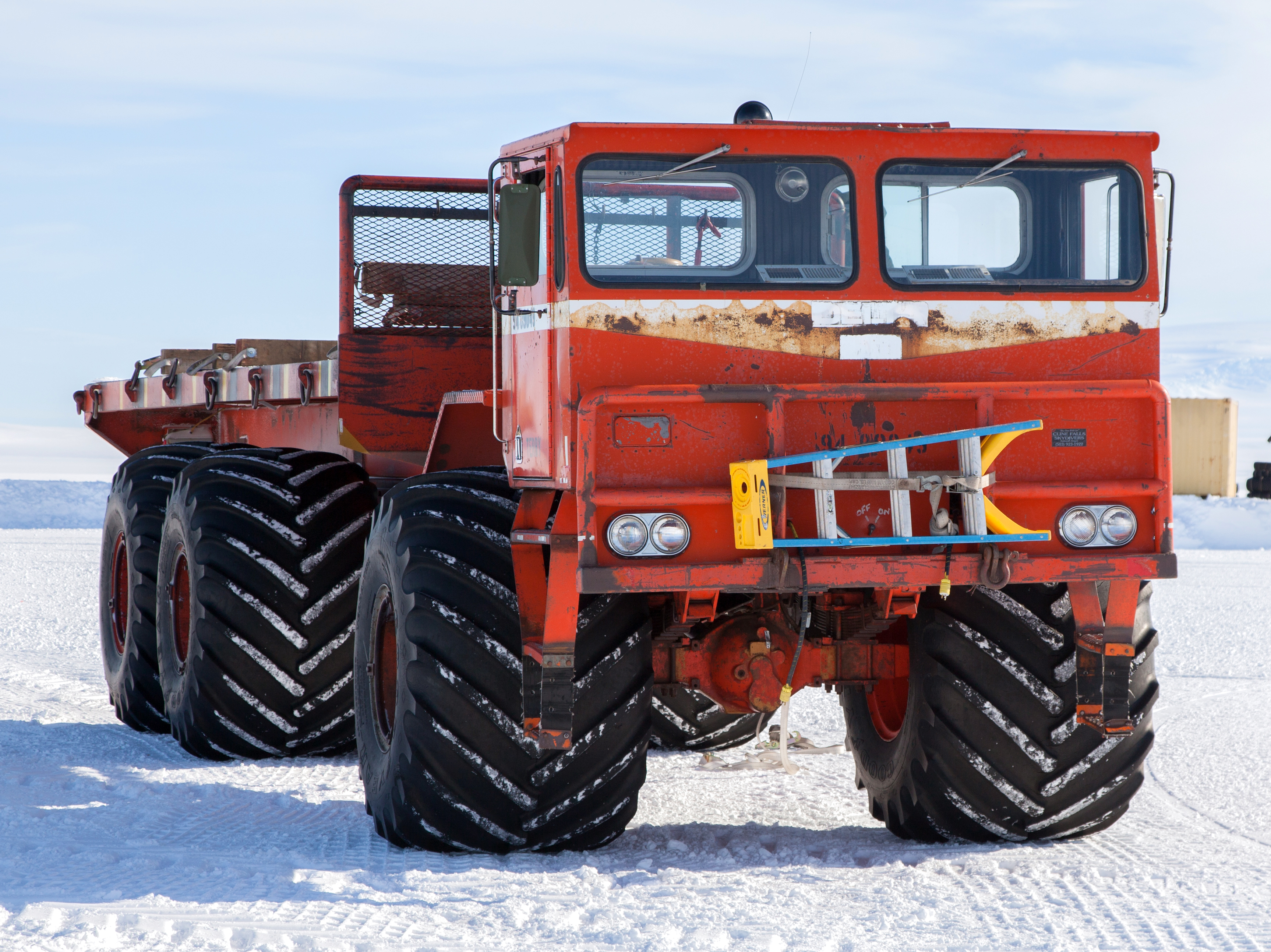Truck with big tires sits on ice.