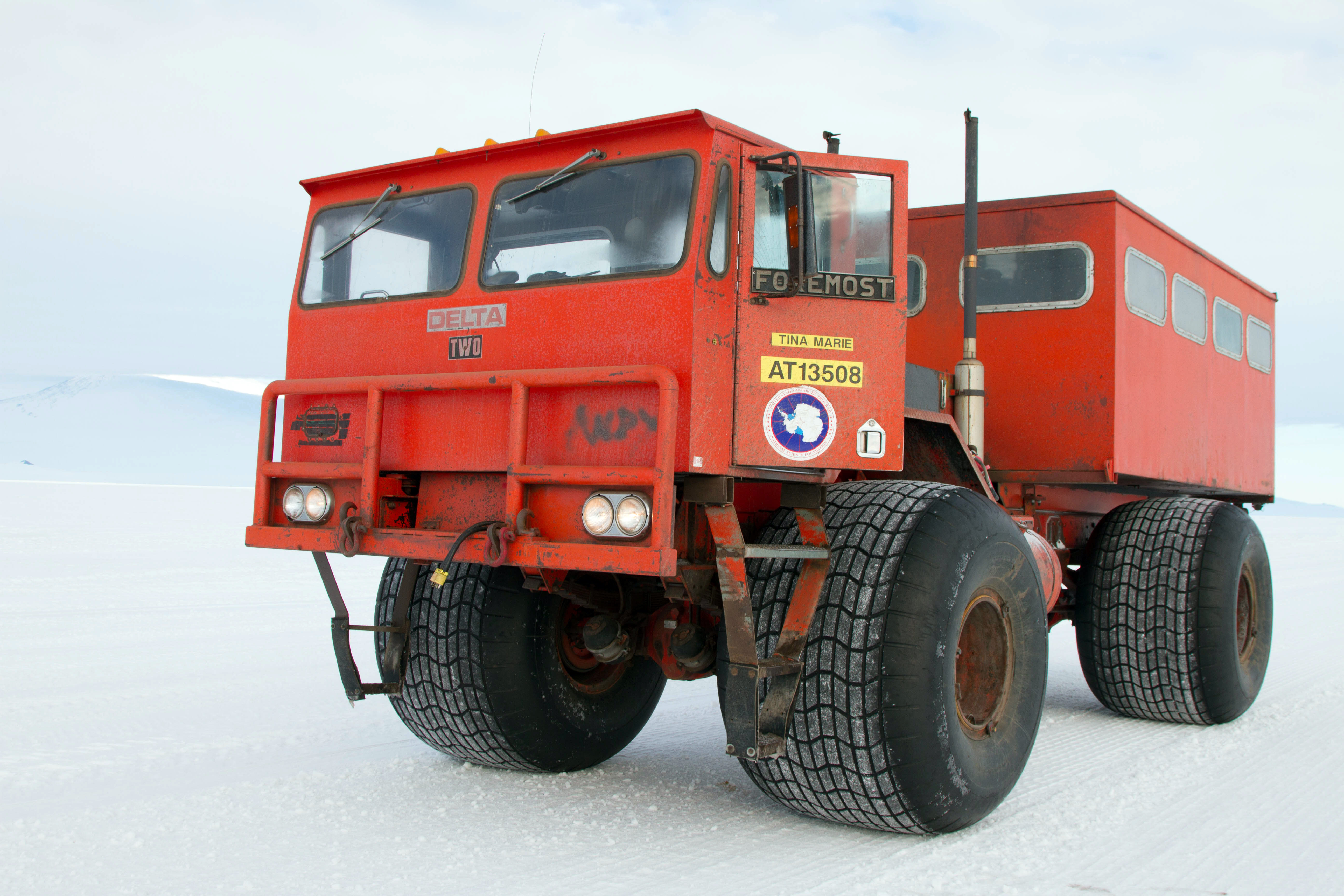 Truck with big tires sits on ice.
