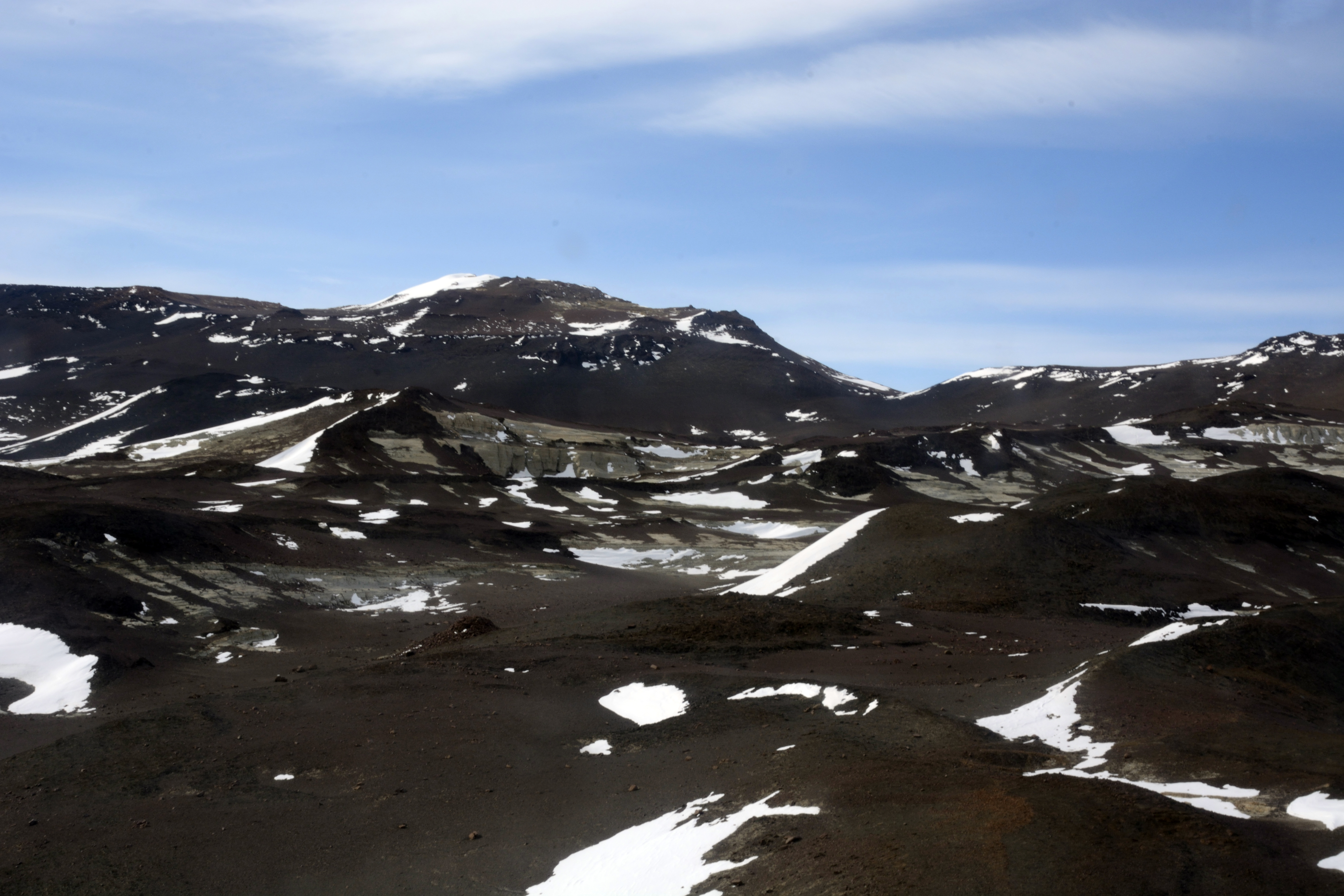 Rock outcrop extends into white snowfield. 