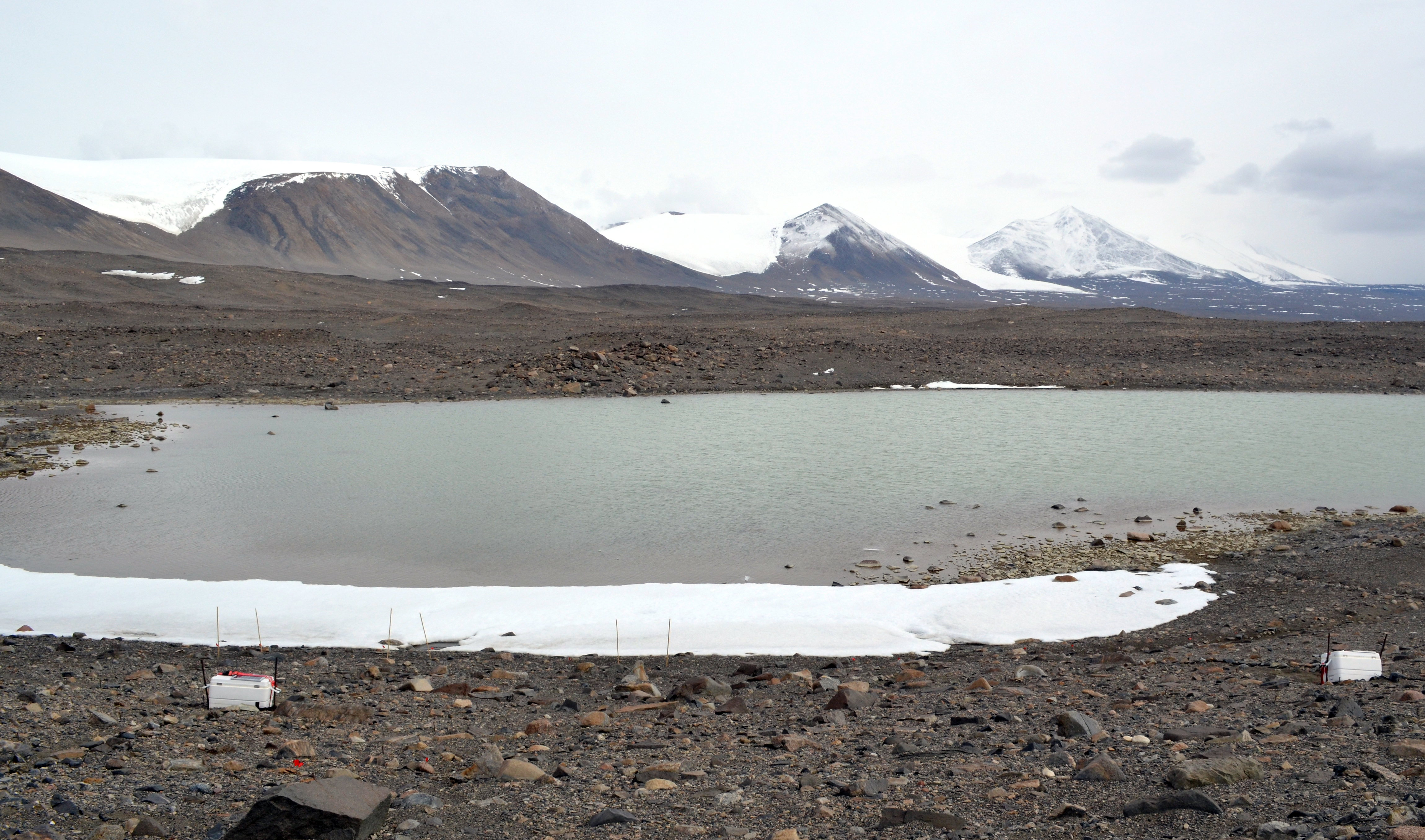 A small lake with mountains in the background.