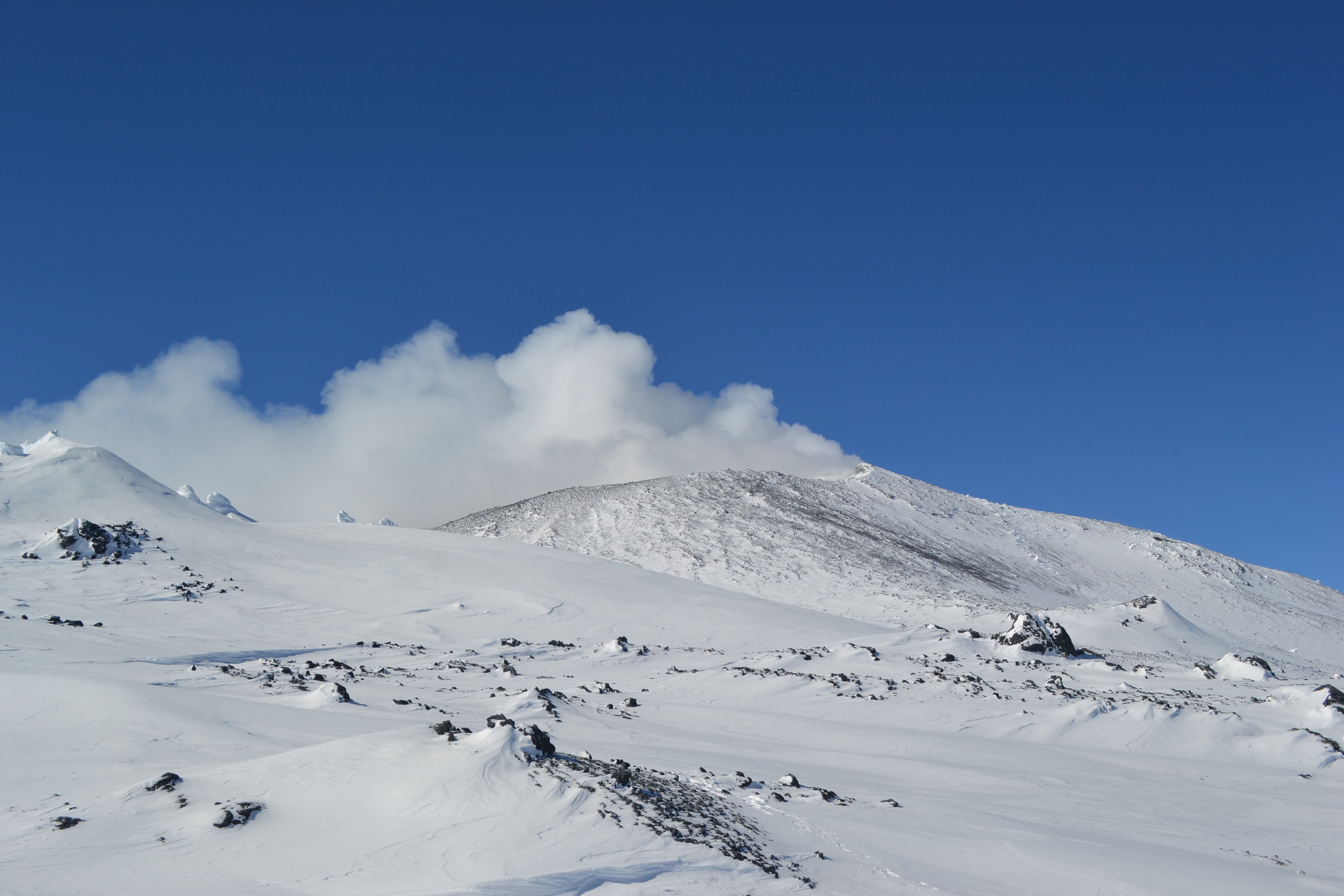 Gas and steam emitted from a volcanic crater rim.