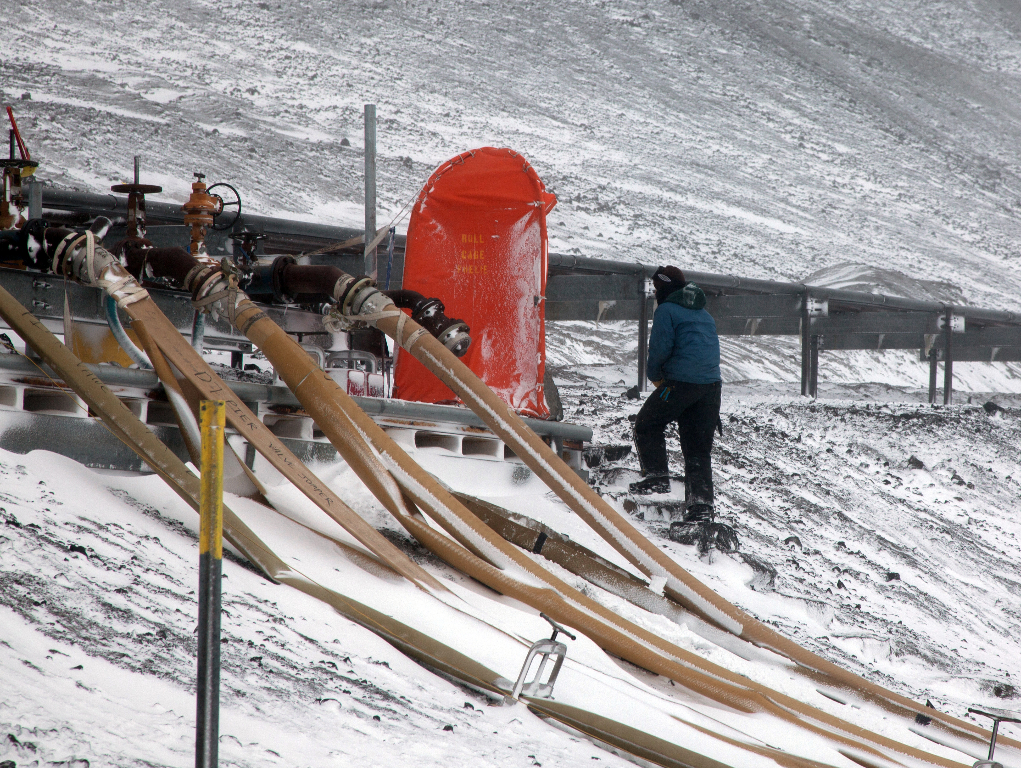 Person stands near a line of hoses.