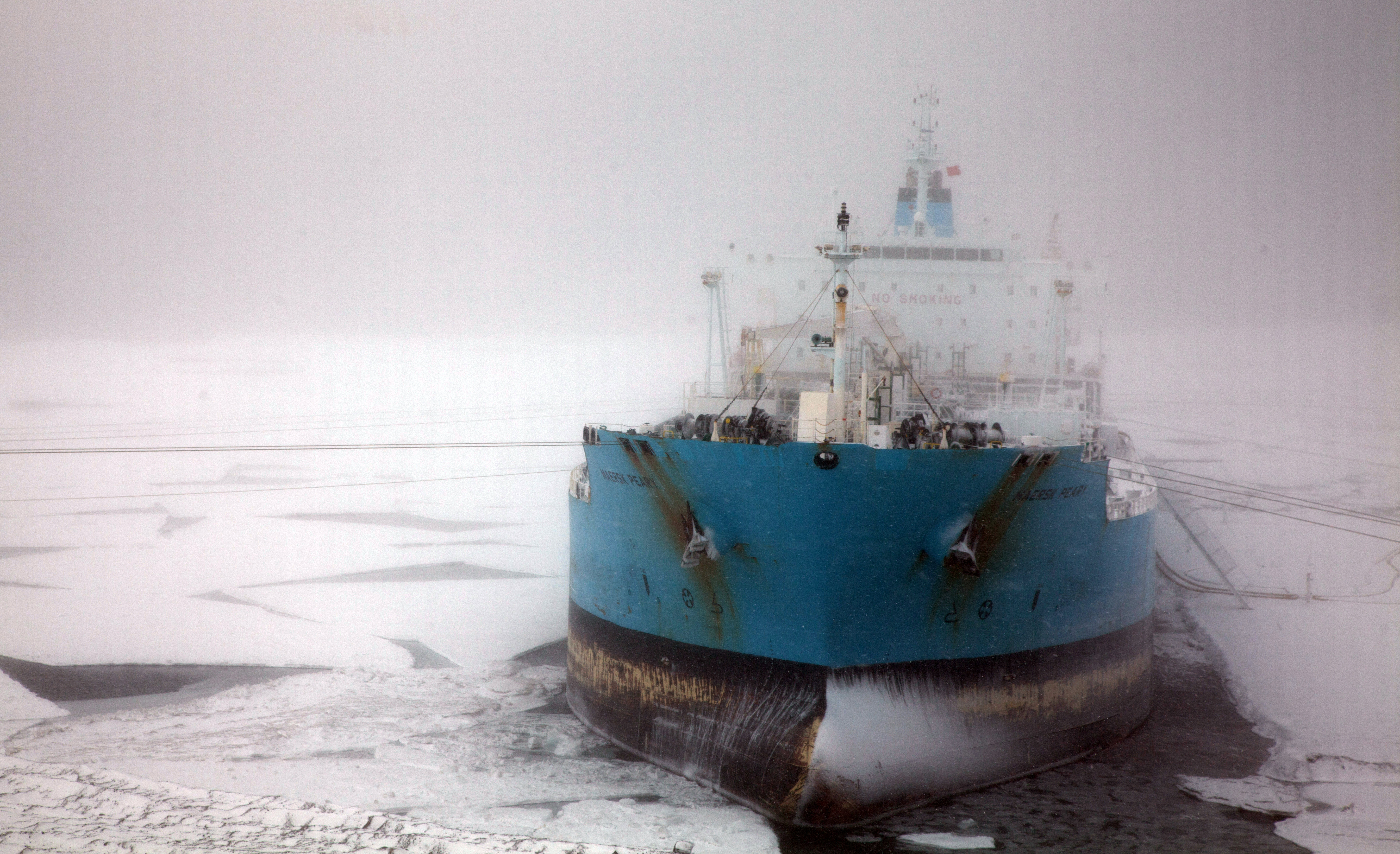 Storm rages around ship docked in ice.