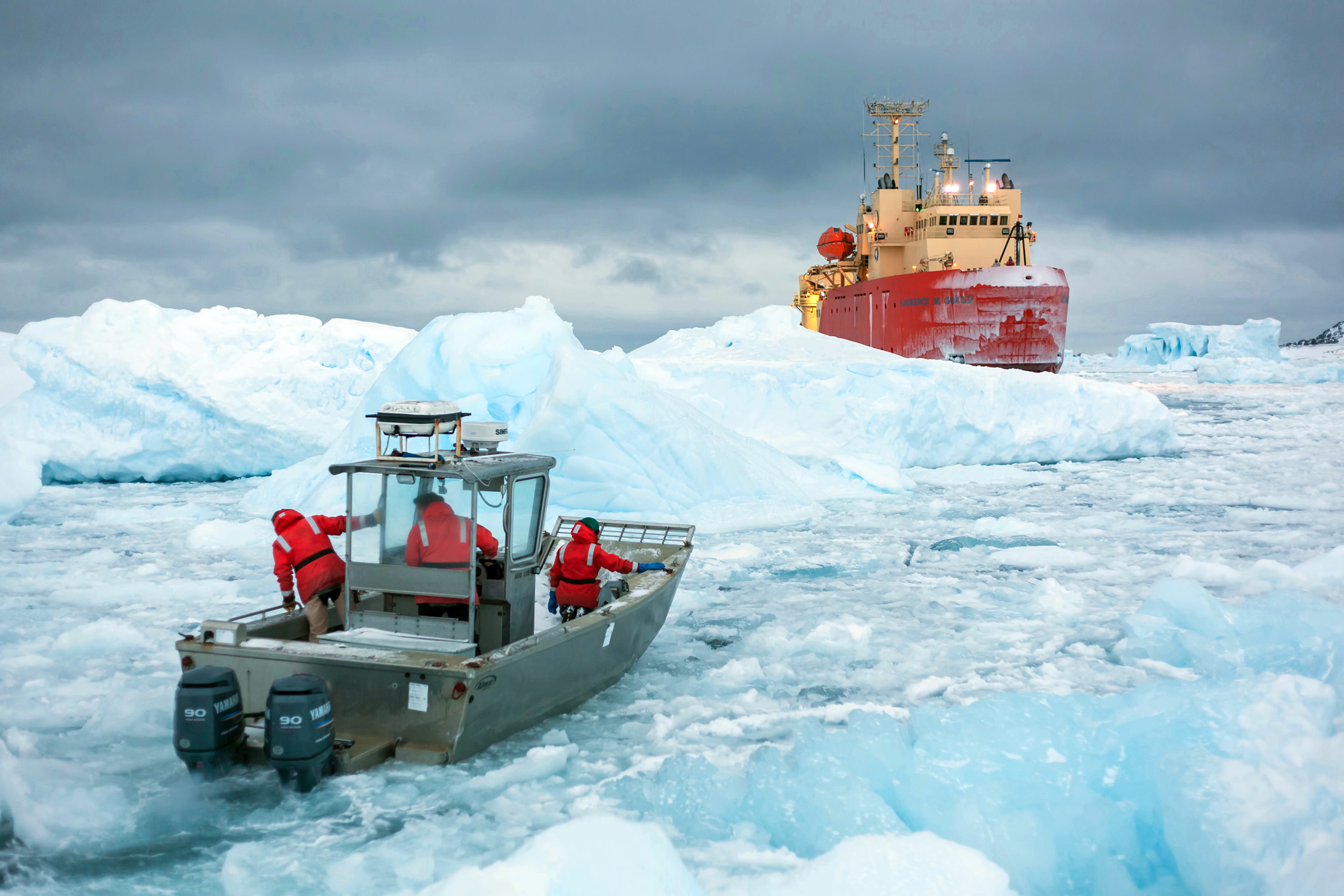 A small boat approaches a larger ship.