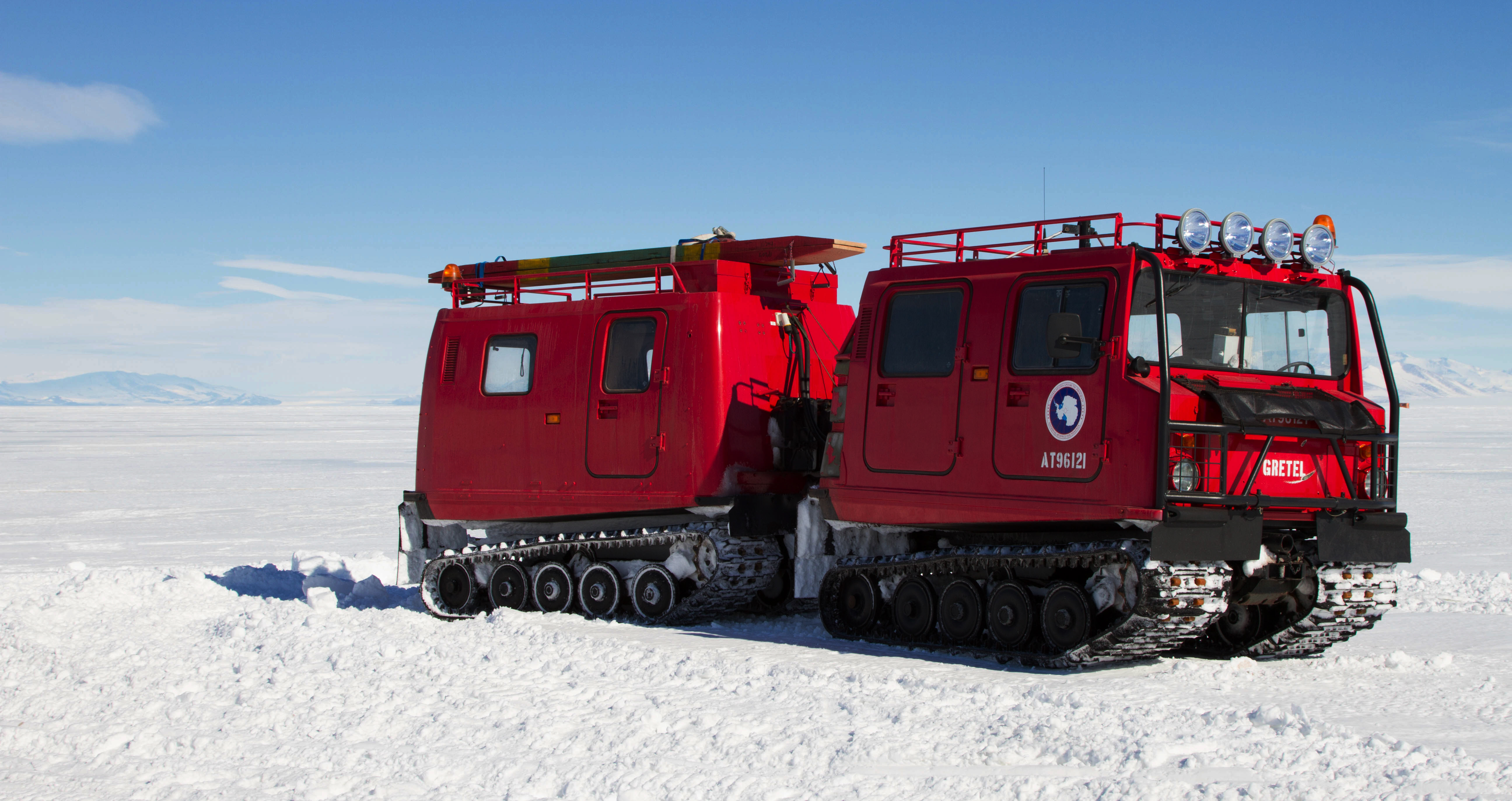 Red vehicle sits on snow.