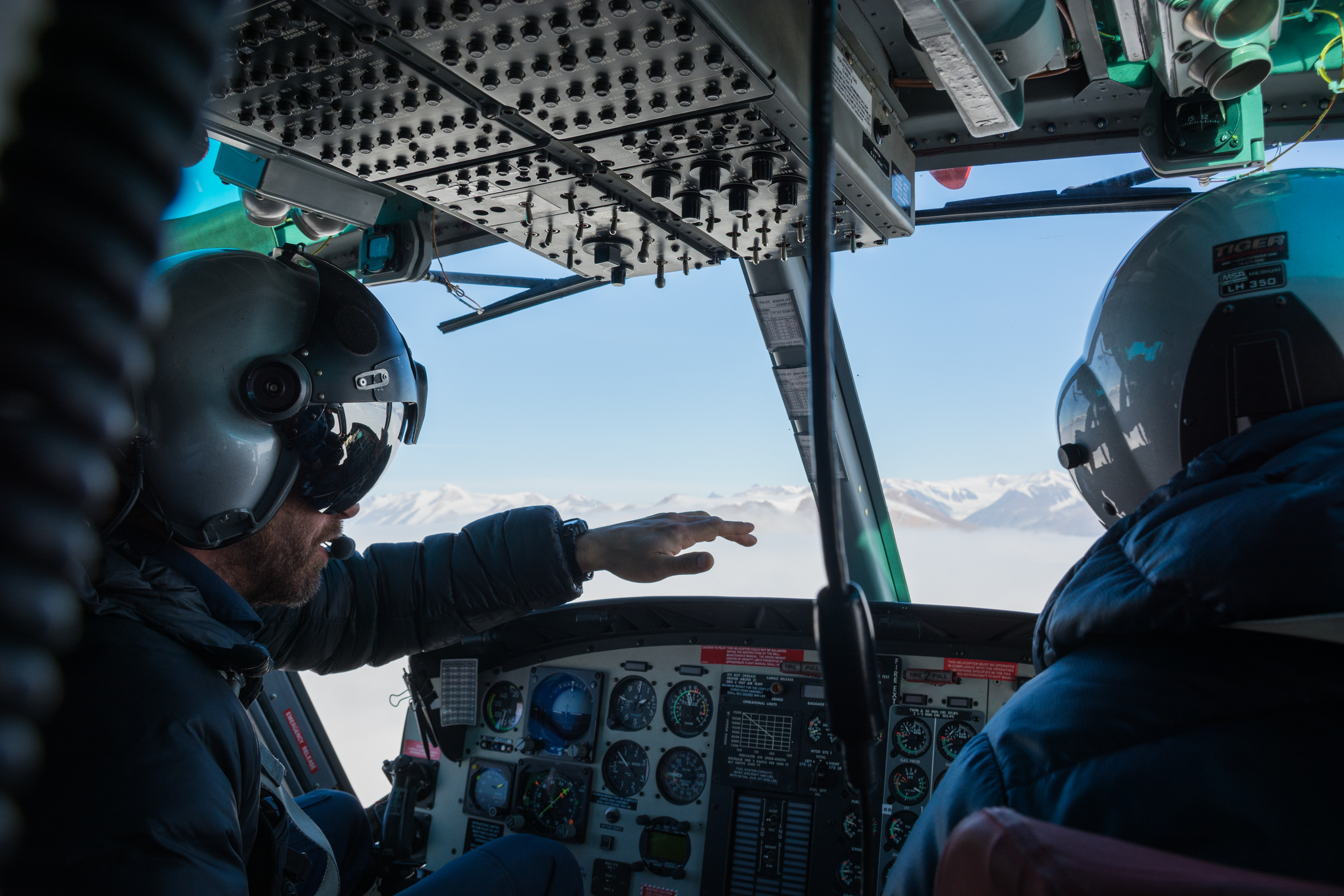 Two helicopter pilots flying in a cockpit.