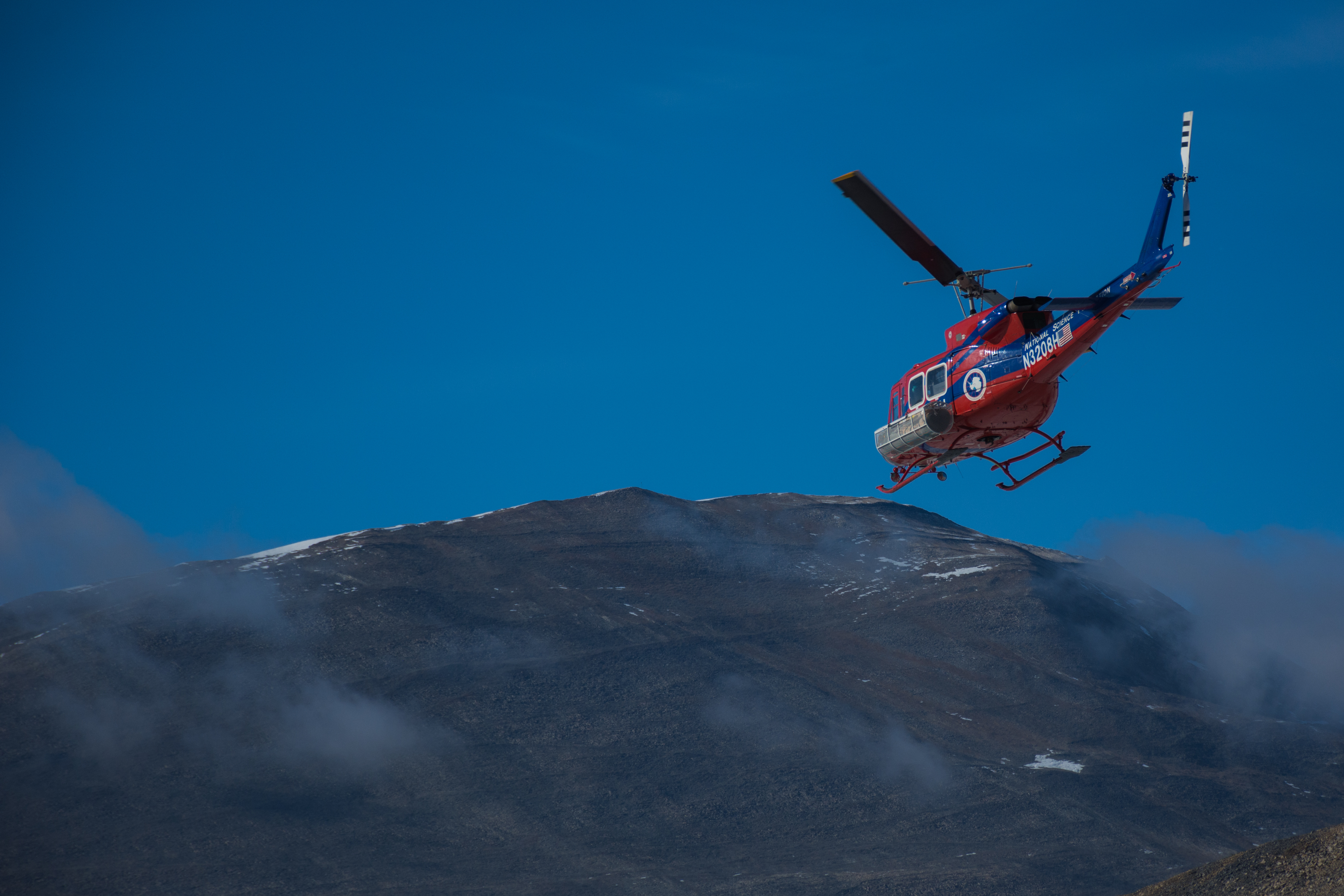 A helicopter flying past hills.