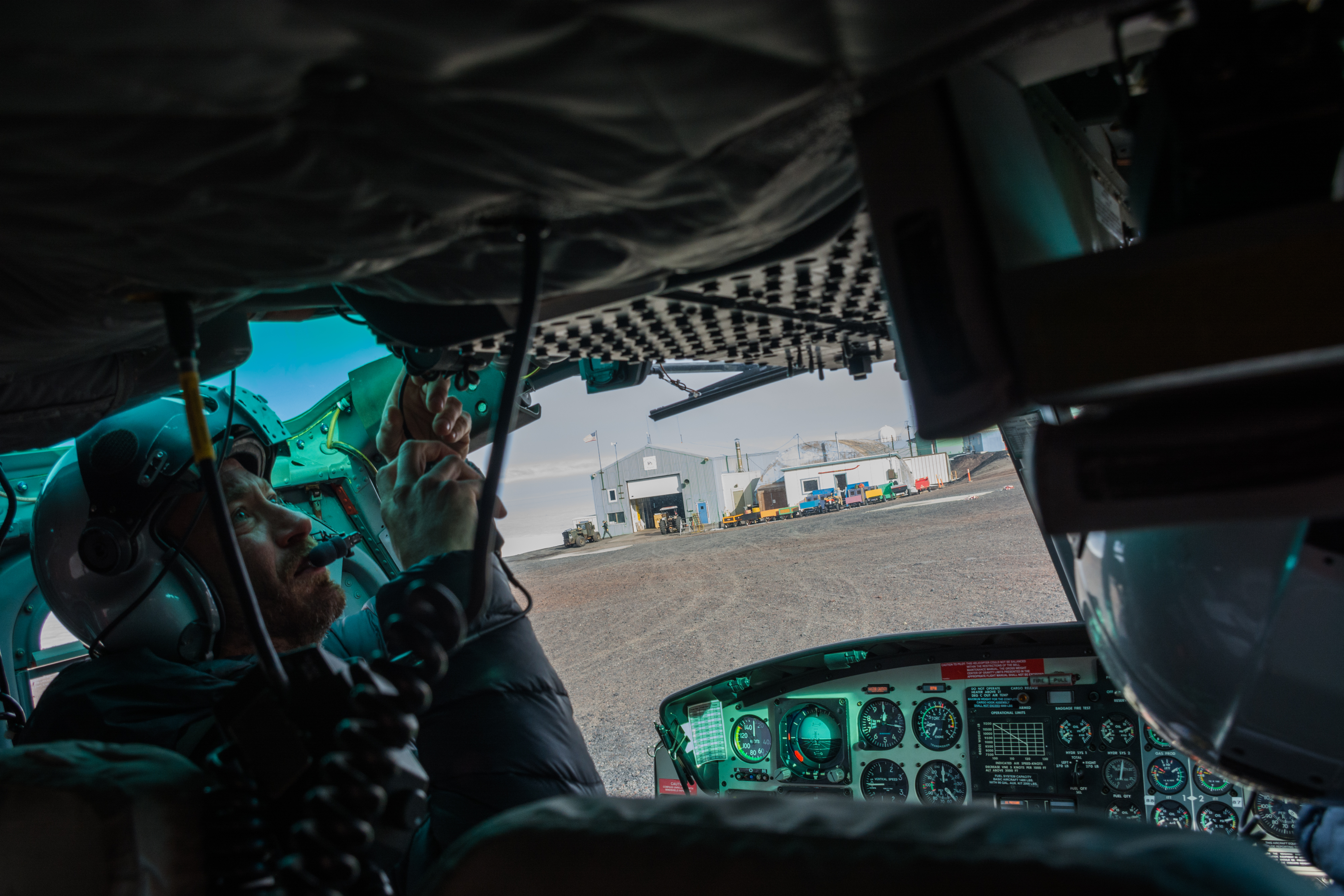 A helicopter pilot adjusts a knob